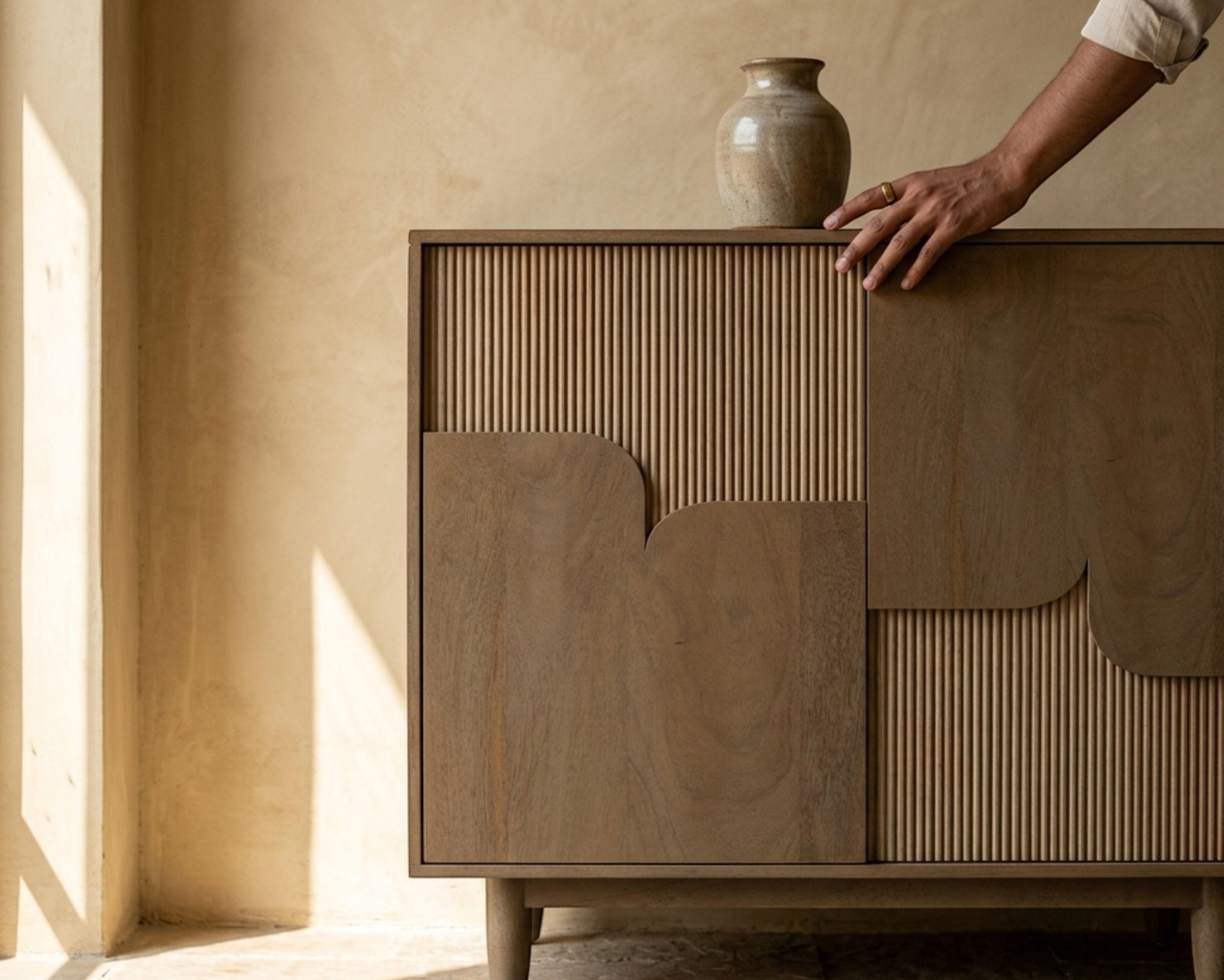 Nakoda Homes Art Deco Ridge Cabinet with fluted wood paneling and asymmetric doors on tapered legs.