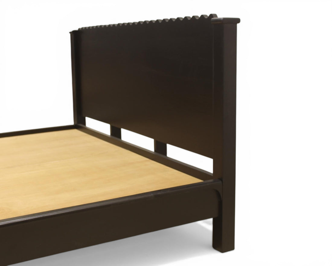 Nakoda Homes modern black wood platform bed frame with scalloped headboard and low profile.