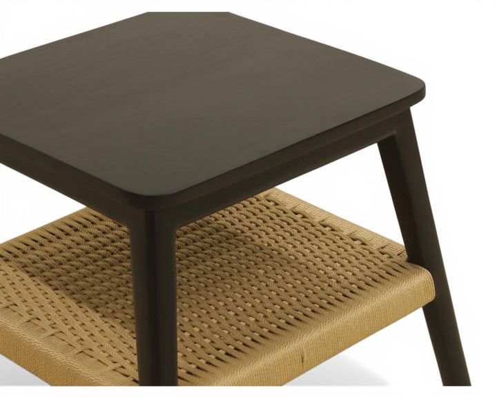 Nakoda Homes black wooden side table with natural woven rattan shelf. Modern accent table.