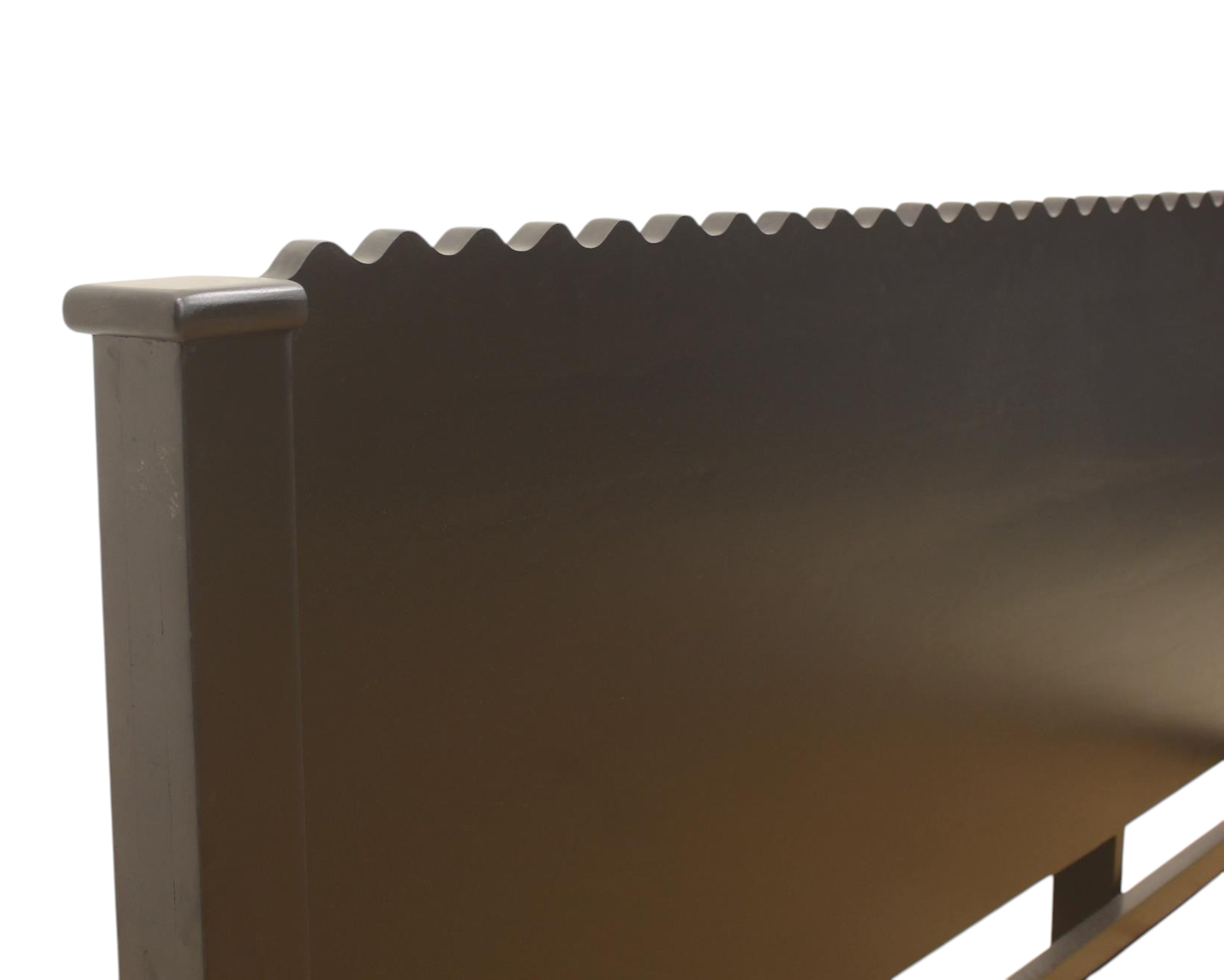 Nakoda Homes black wood platform bed frame with scalloped headboard detail.