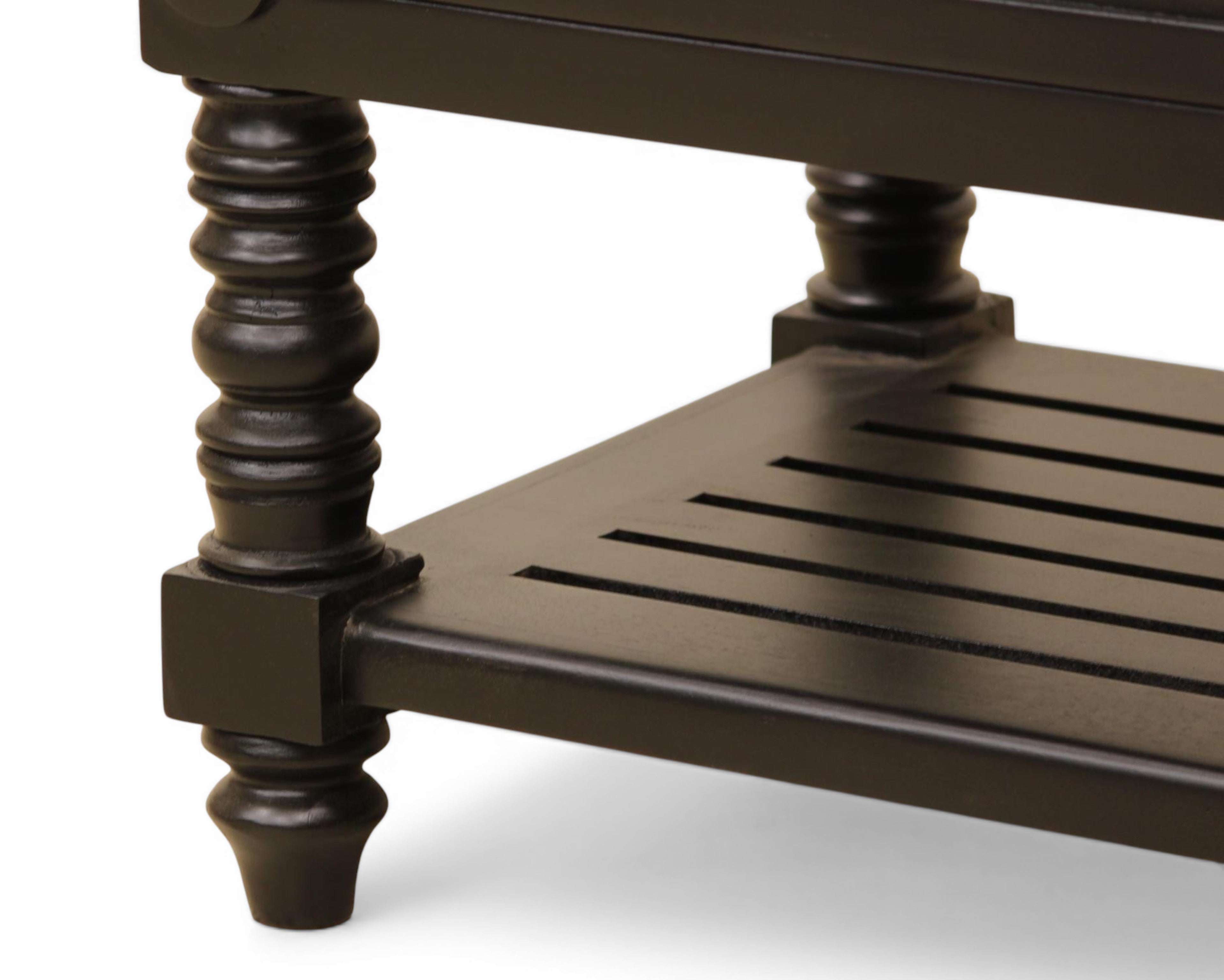 Nakoda Homes black wooden nightstand with two drawers, gold hardware, turned legs, and slatted shelf.