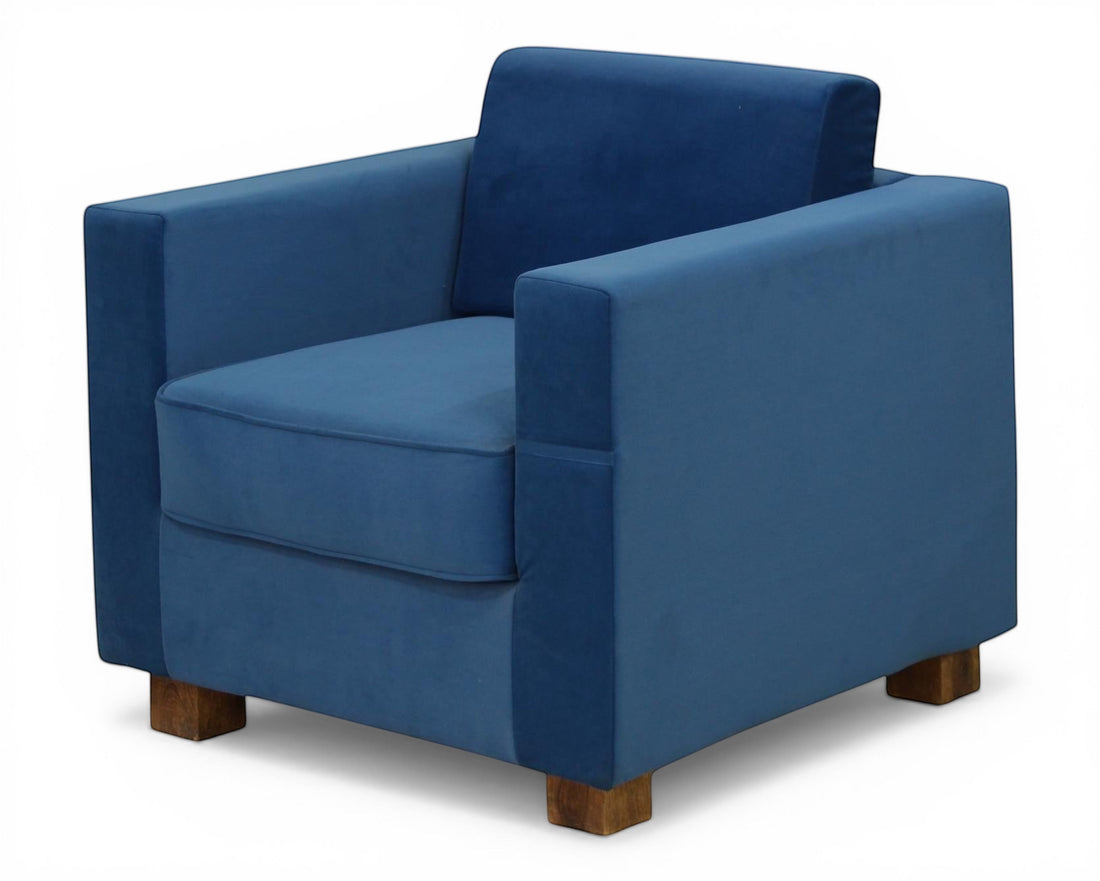Nakoda Homes blue velvet armchair with modern clean lines and wooden block feet. Plush upholstery for comfort and style.