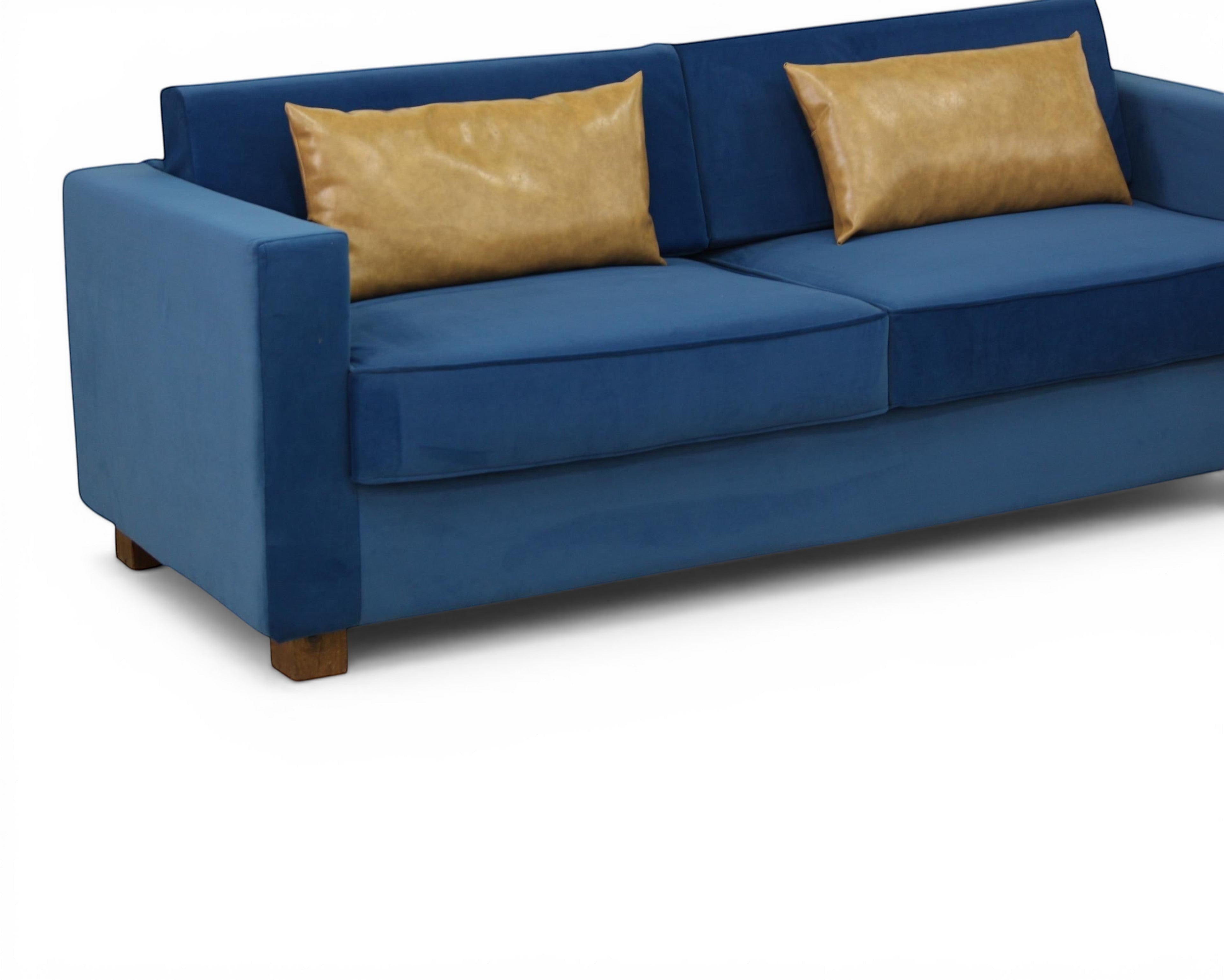 Nakoda Homes blue velvet sofa with tan accent pillows, modern design, plush upholstery, and clean lines.