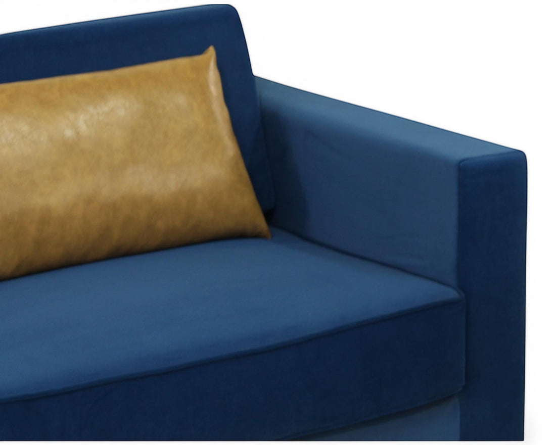 Nakoda Homes blue velvet sofa with tan accent pillow, modern design, plush upholstery, and clean lines.