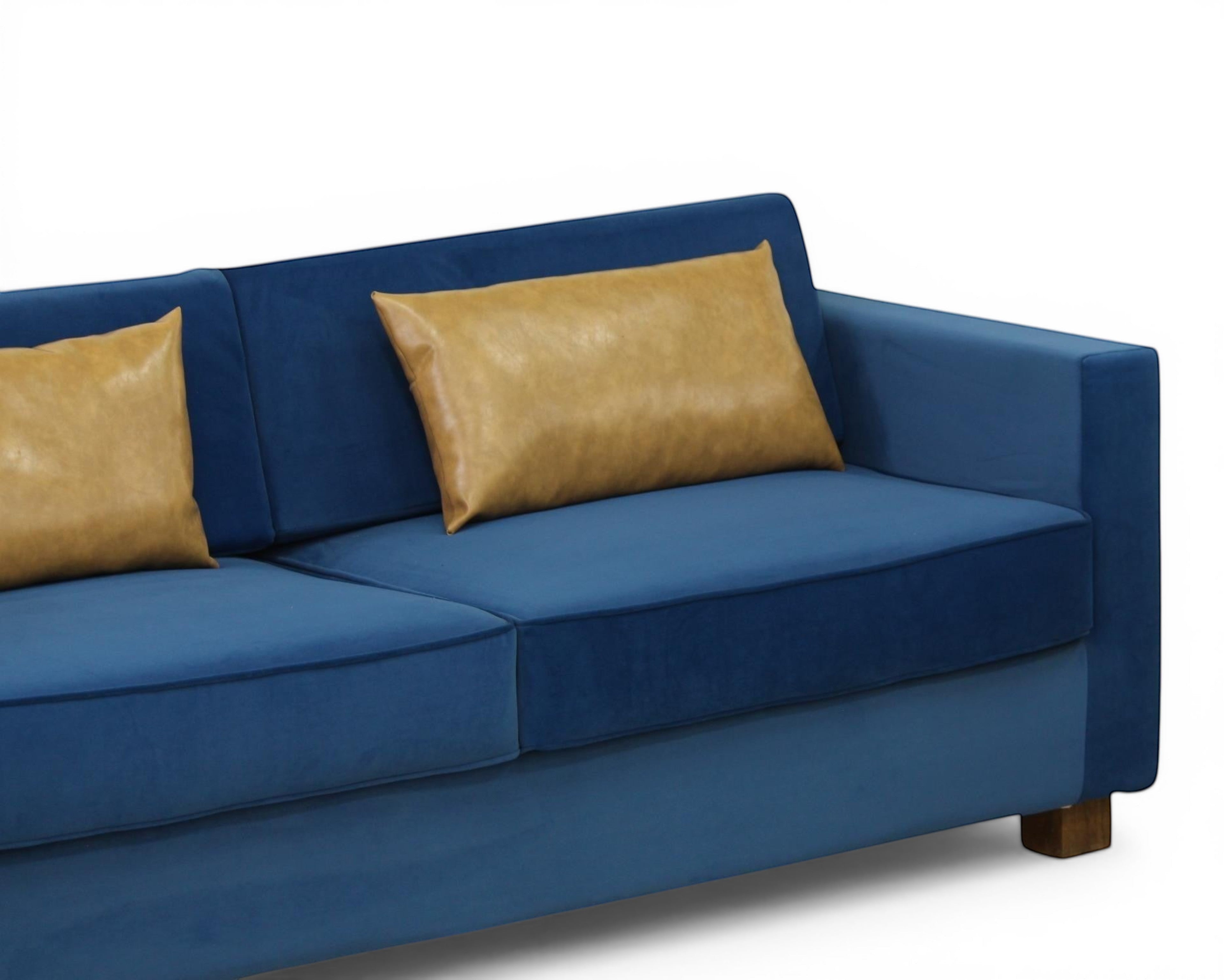 Nakoda Homes blue velvet sofa with tan accent pillows, modern design, plush upholstery, and clean lines.
