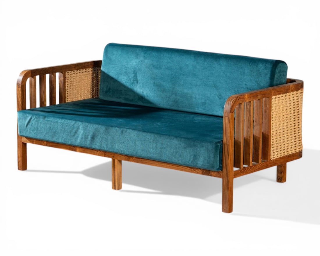 Nakoda Homes 3-seater sofa with deep teal velvet upholstery and natural wood frame with cane detailing.