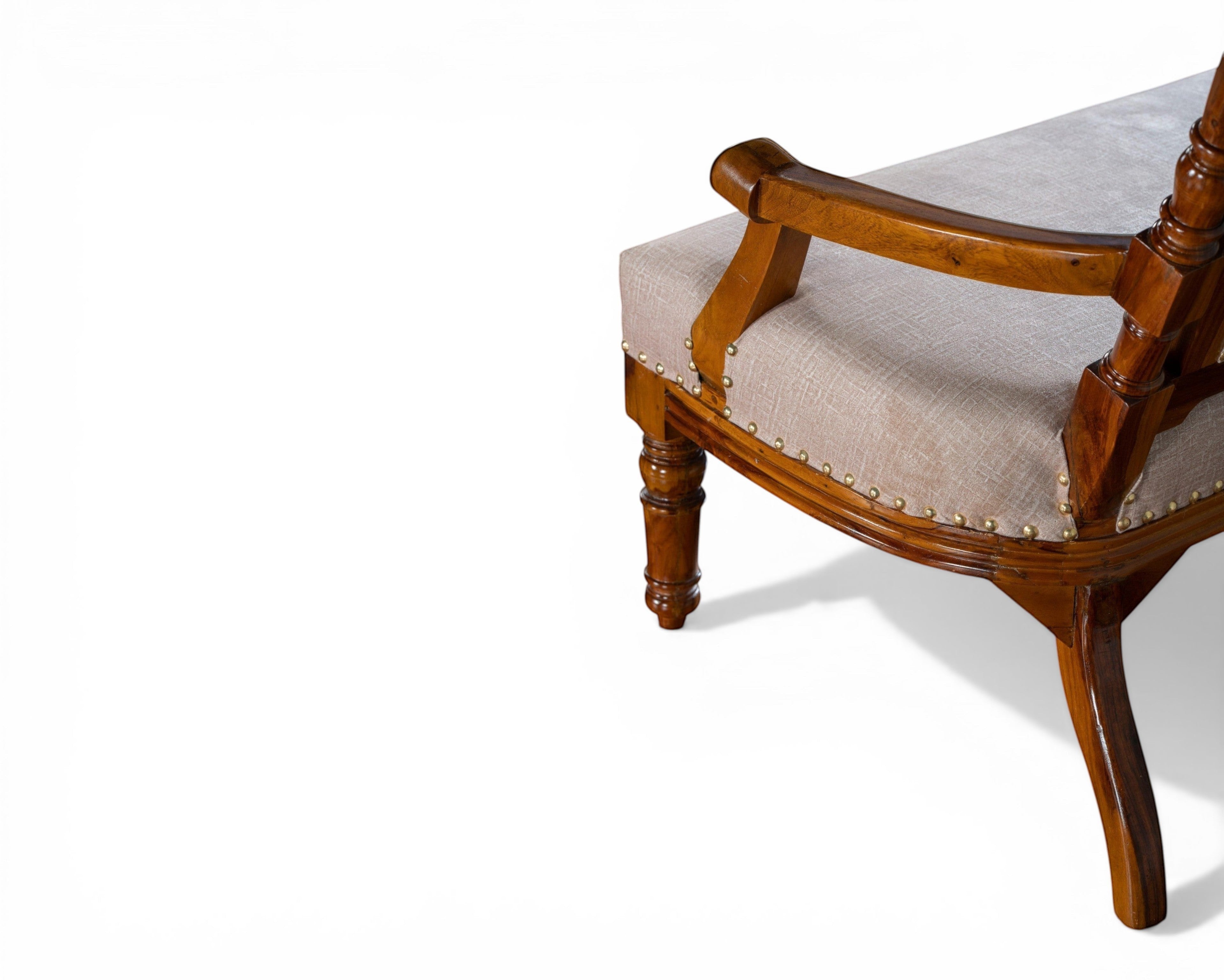 Nakoda Homes ornate carved wood armchair with neutral upholstered seat and decorative nailhead trim.