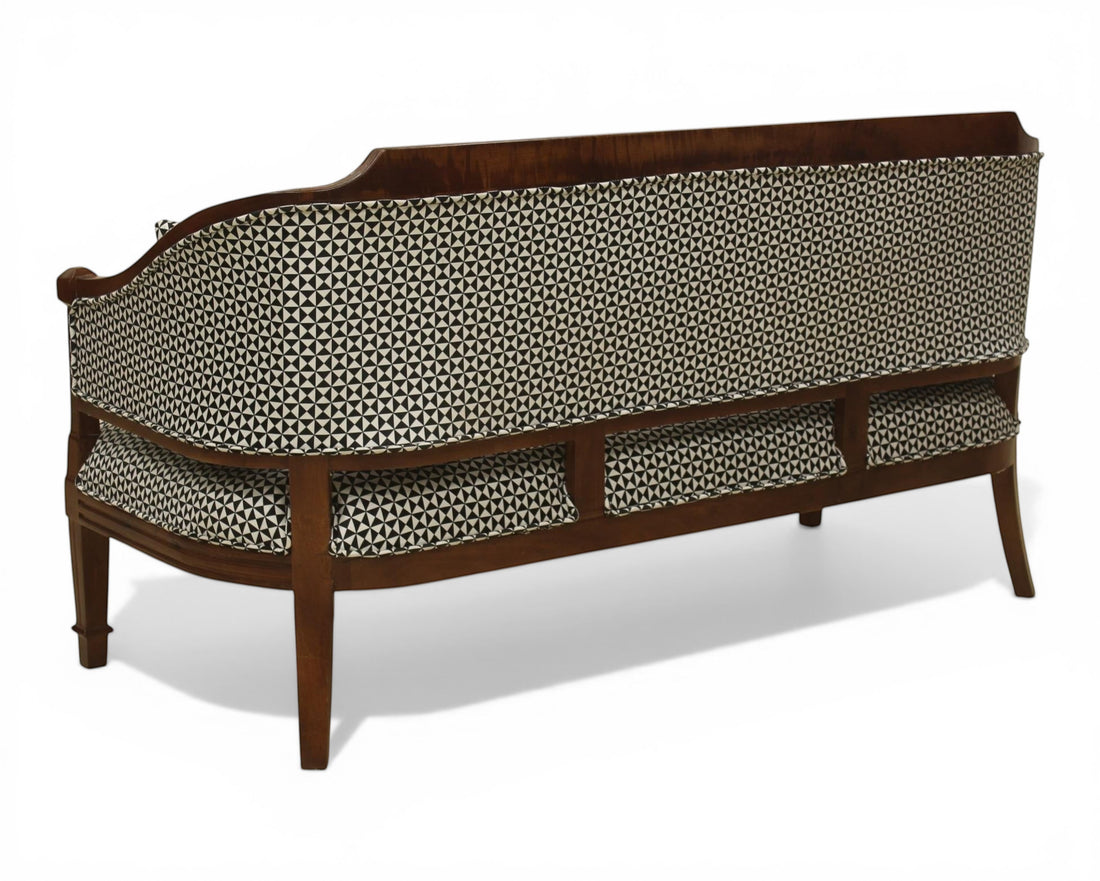 Nakoda Homes classic wooden armchair with black and white geometric patterned upholstery and accent pillows.