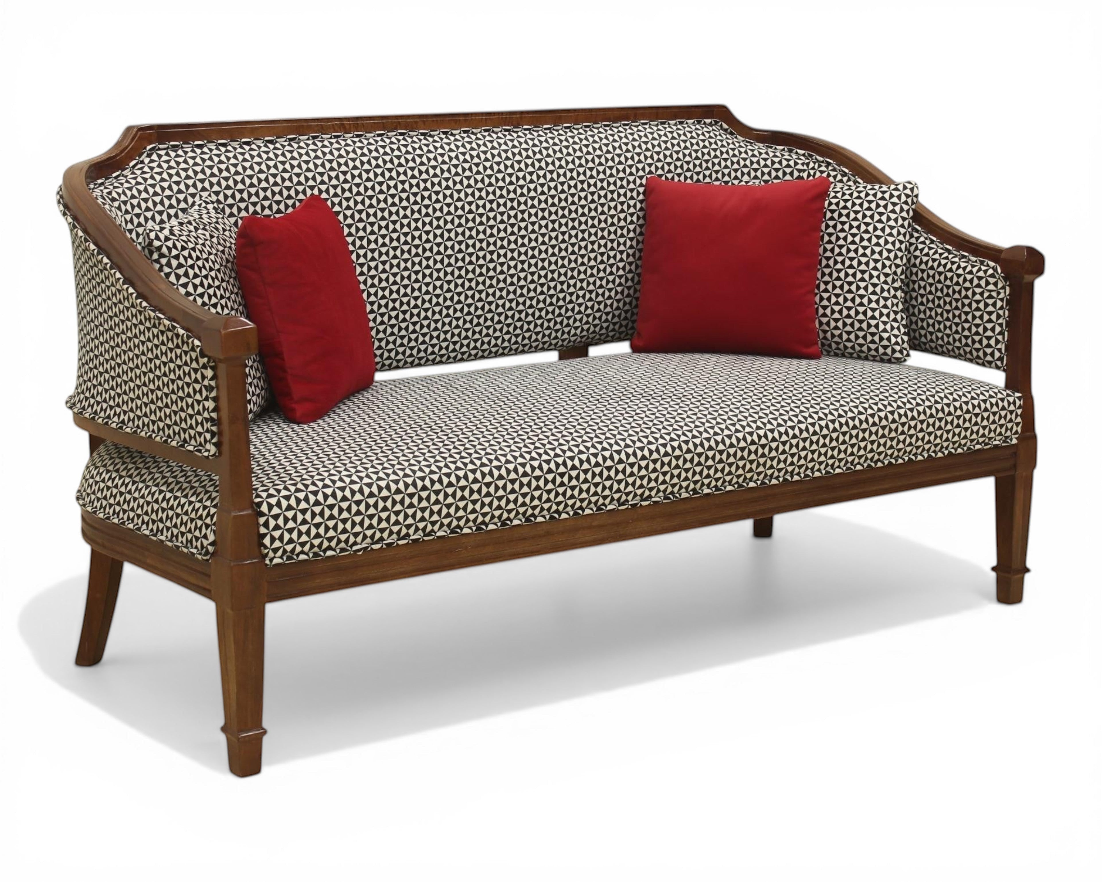 Nakoda Homes classic armchair and sofa set with wooden frame, black and white geometric pattern upholstery, and red accent pillows.