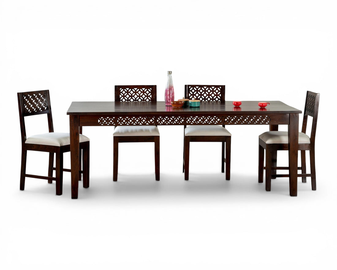 Nakoda Homes dark wood dining set with white upholstered chairs and intricate geometric carvings.