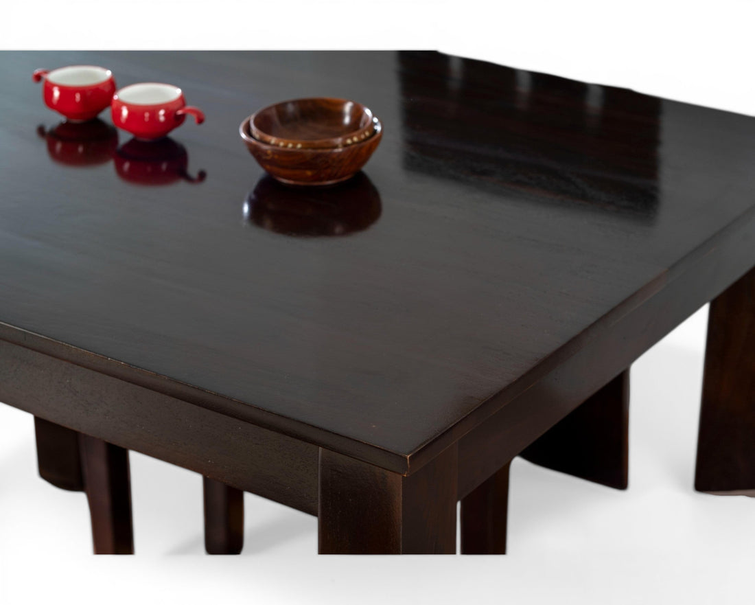 Nakoda Homes dark wood 4-seater dining set with cushioned chairs and a smooth table surface.