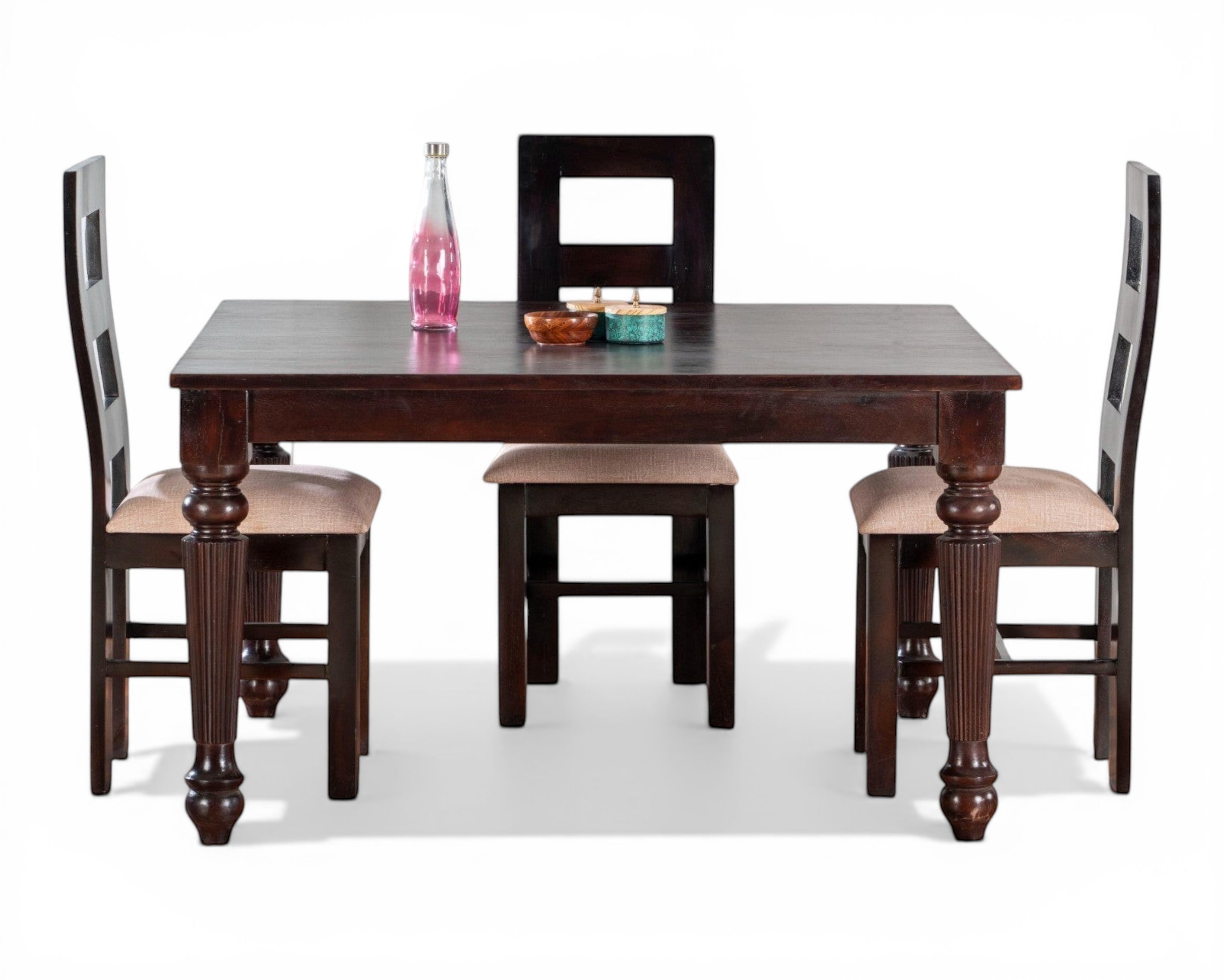 Nakoda Homes dark wood dining set with turned legs. Includes table and four chairs, two with neutral upholstered seats.