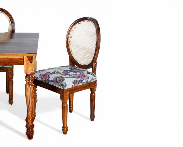 Nakoda Homes floral upholstered cane back dining chair with carved wooden frame and ornate legs.