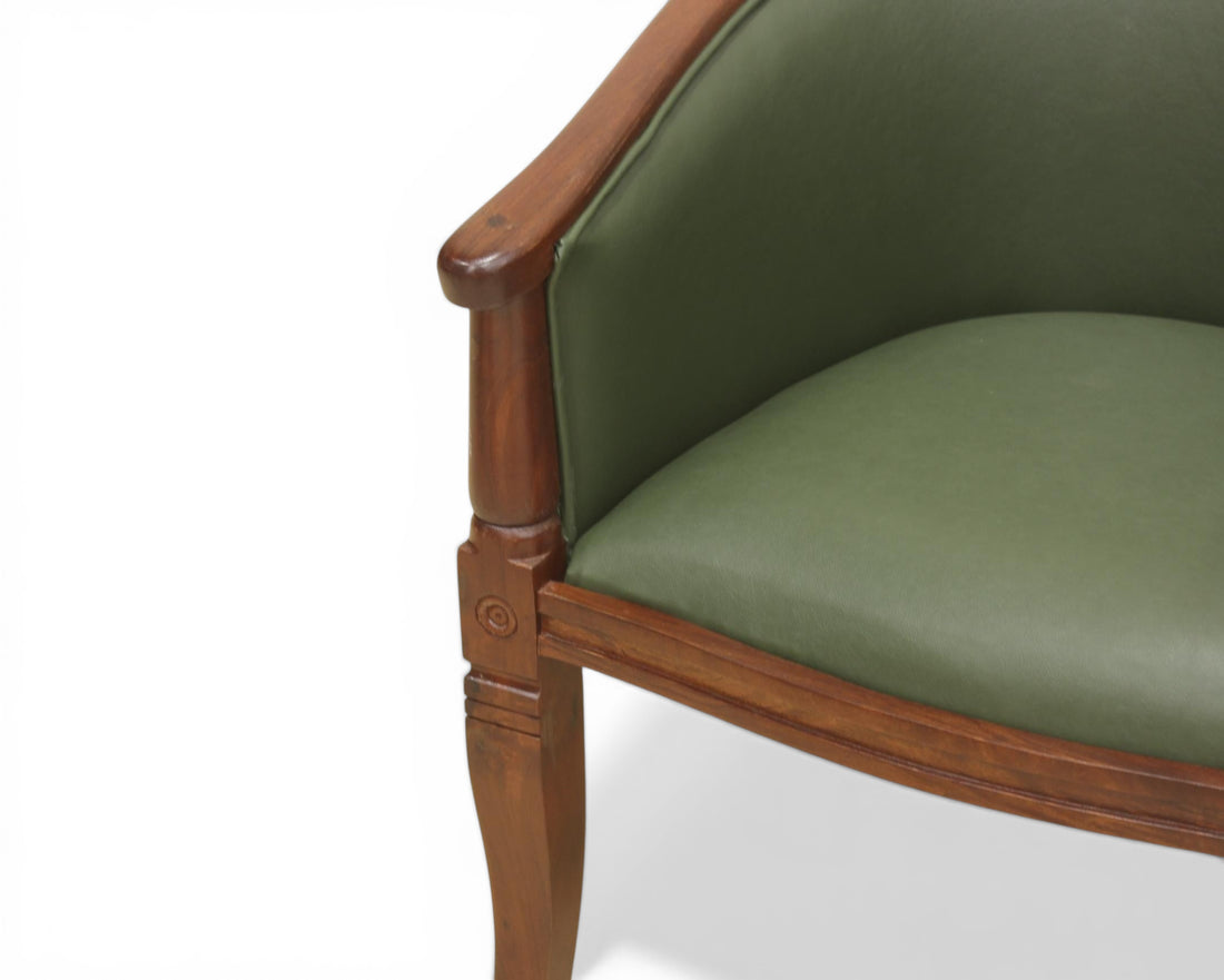 Nakoda Homes forest green faux leather barrel-back accent chair with dark wood frame and turned legs.