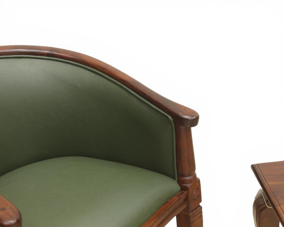 Nakoda Homes forest green faux leather barrel-back accent chair with dark wood frame and turned legs.