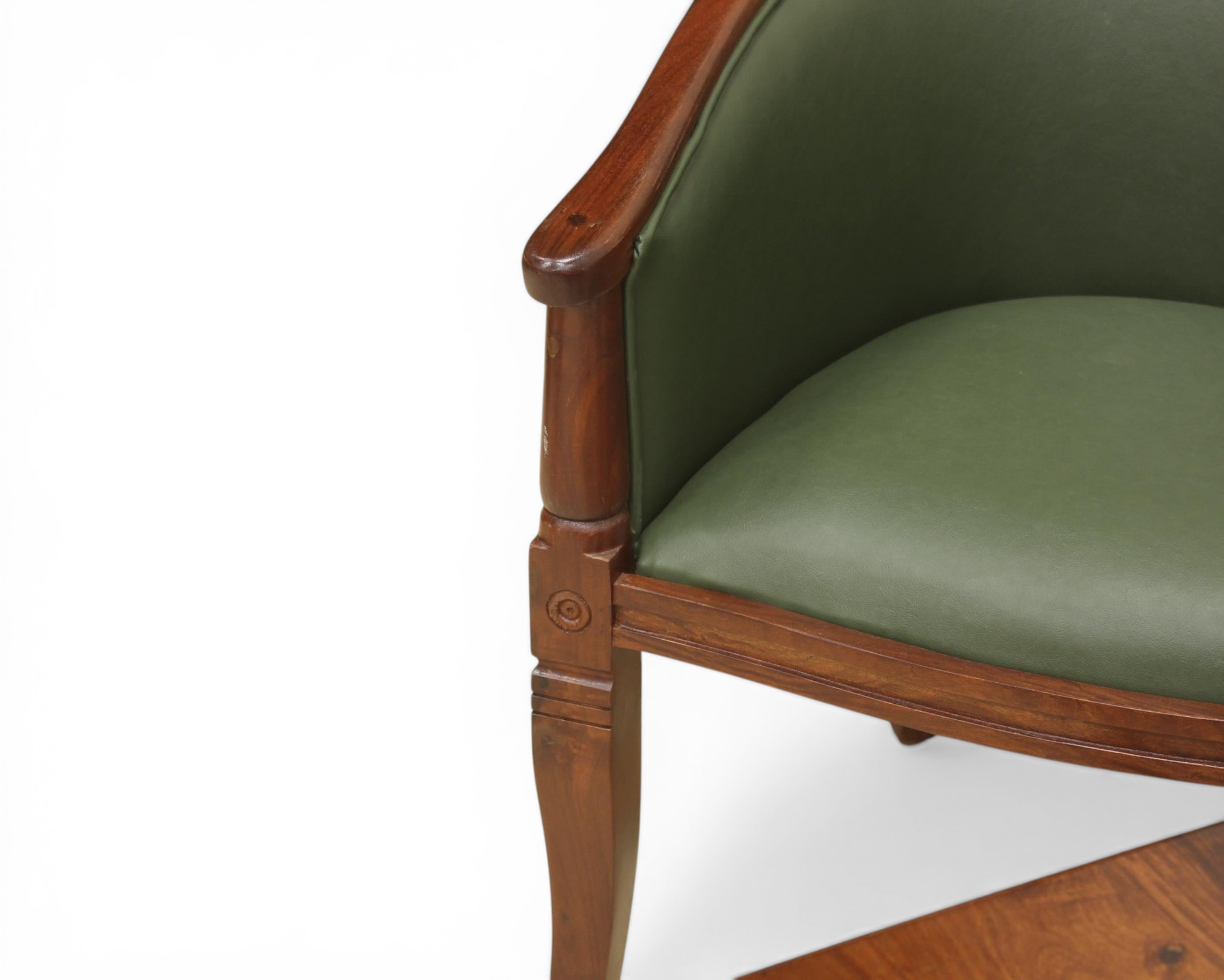 Nakoda Homes forest green faux leather barrel-back accent chair with dark wood frame and turned legs.