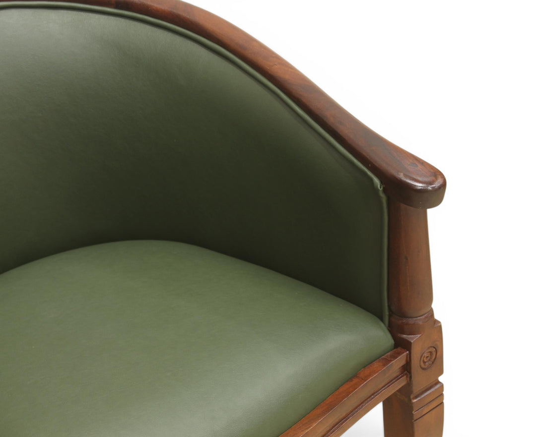 Nakoda Homes forest green faux leather barrel-back accent chair with dark wood frame and turned legs.