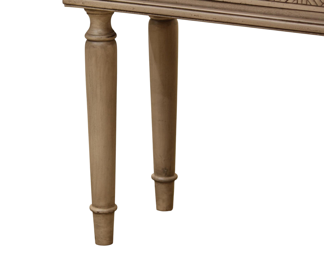 Nakoda Homes distressed grey wood console table with carved drawers and brass knobs, featuring turned legs.