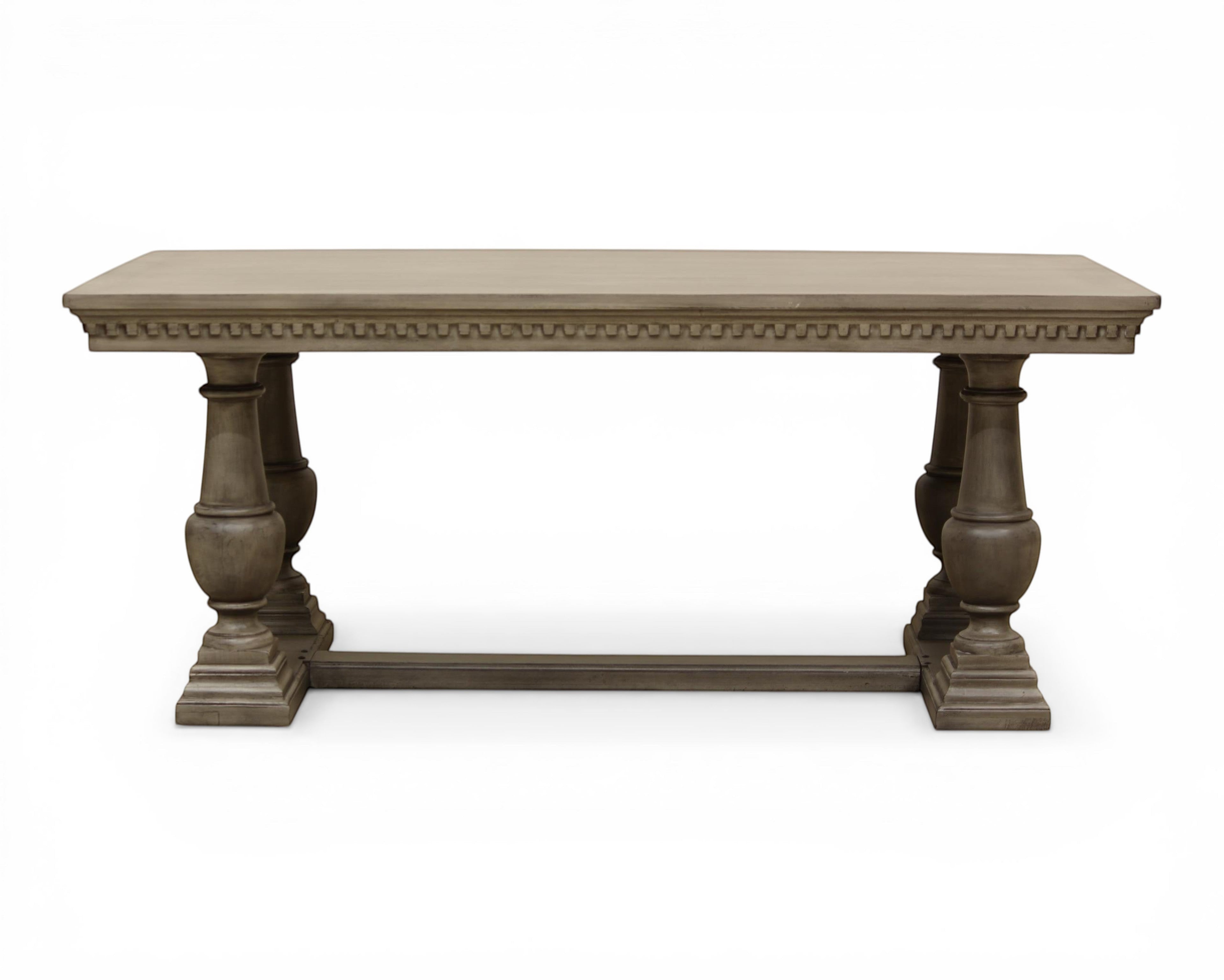 Nakoda Homes grey wood console table with rectangular top and decorative carved edge, pedestal legs, and base.
