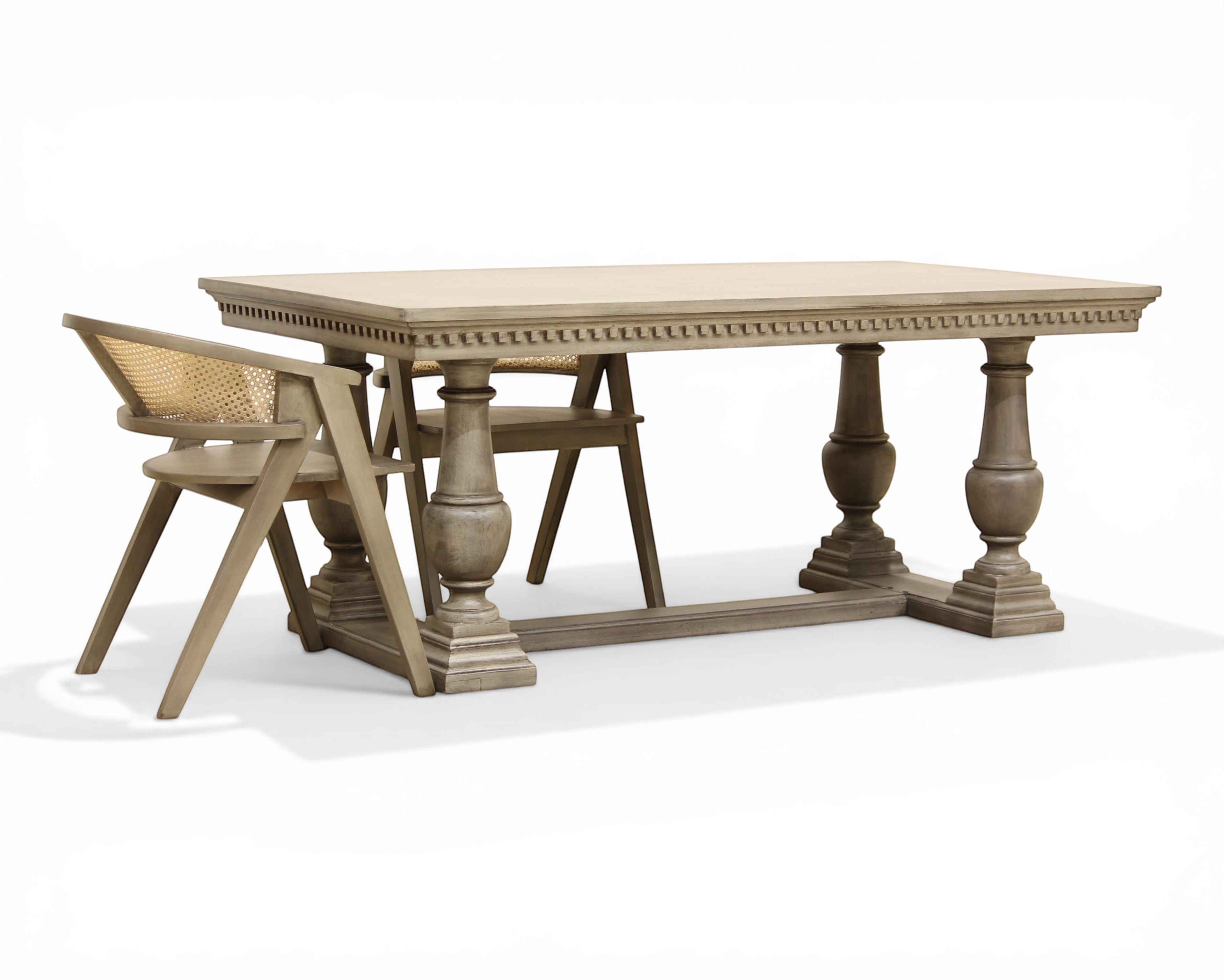 Nakoda Homes grey wood dining table with carved edge and pedestal legs. Rectangular top, classic elegance.