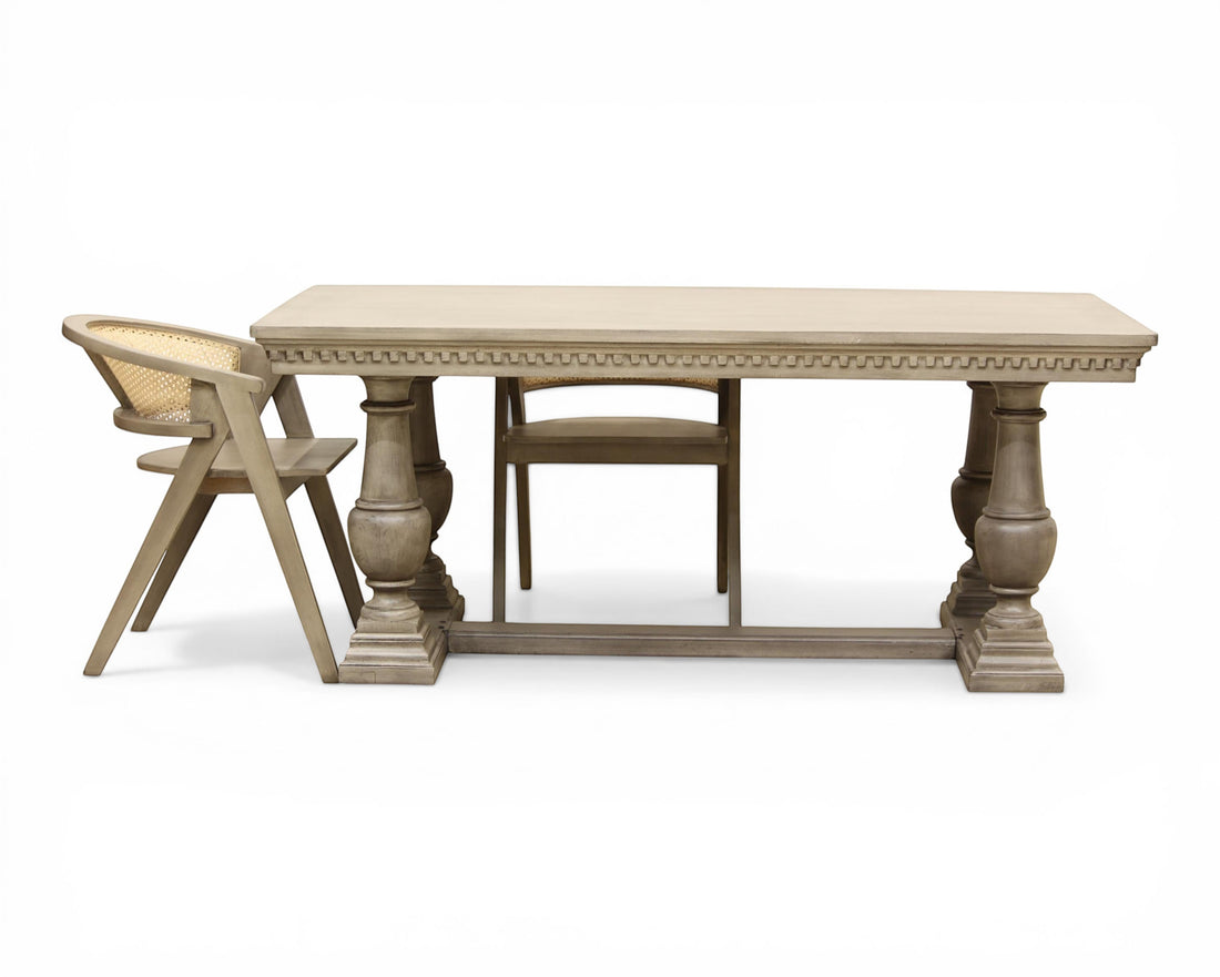 Nakoda Homes ornate grey wood dining table with carved edge and pedestal legs. Rectangular top, classic elegance.