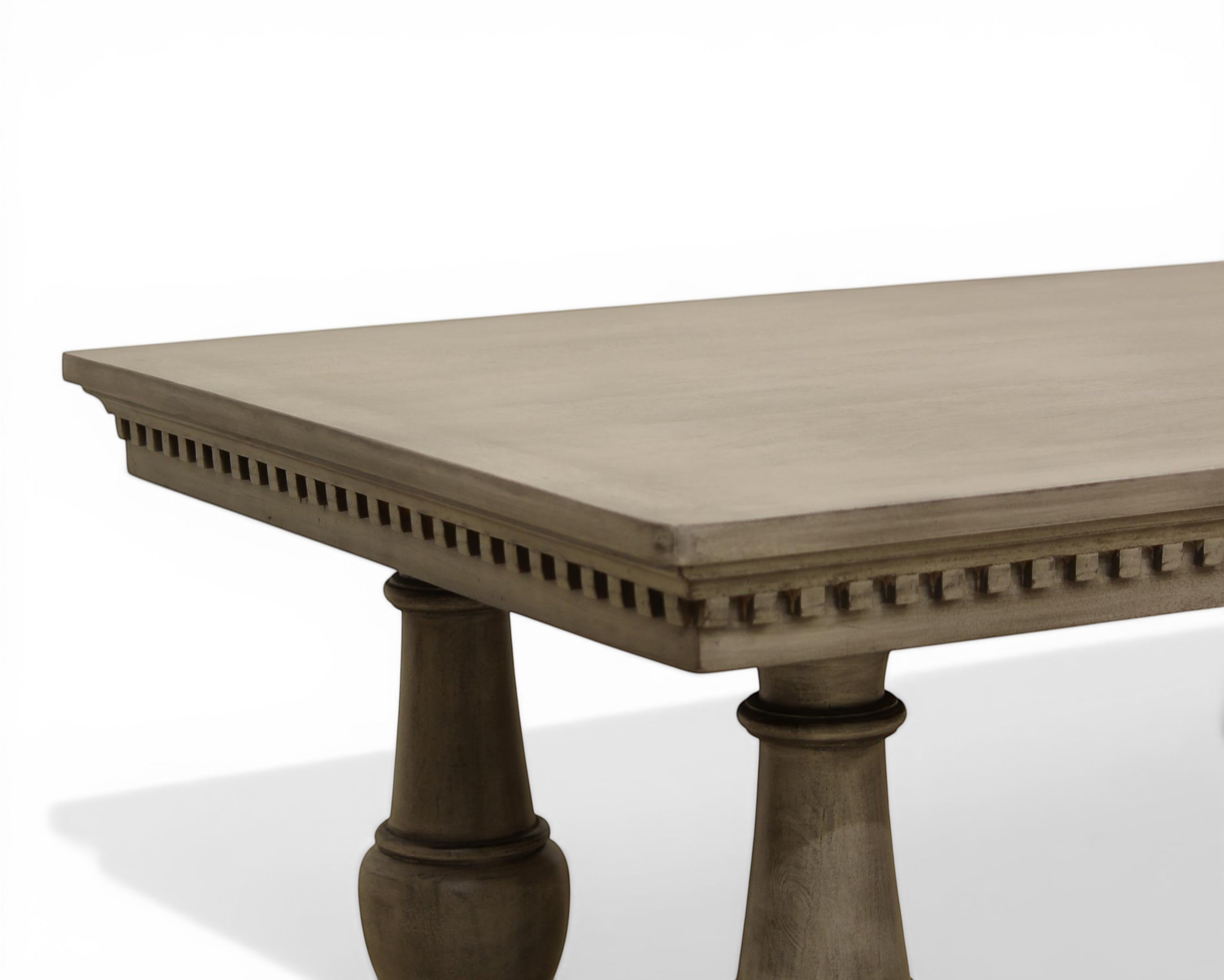 Nakoda Homes grey wood console table with carved edge detail and pedestal legs. Rectangular top.