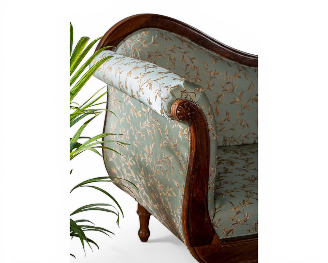 Nakoda Homes light blue floral fabric chaise lounge with dark wood frame and ornate detailing.