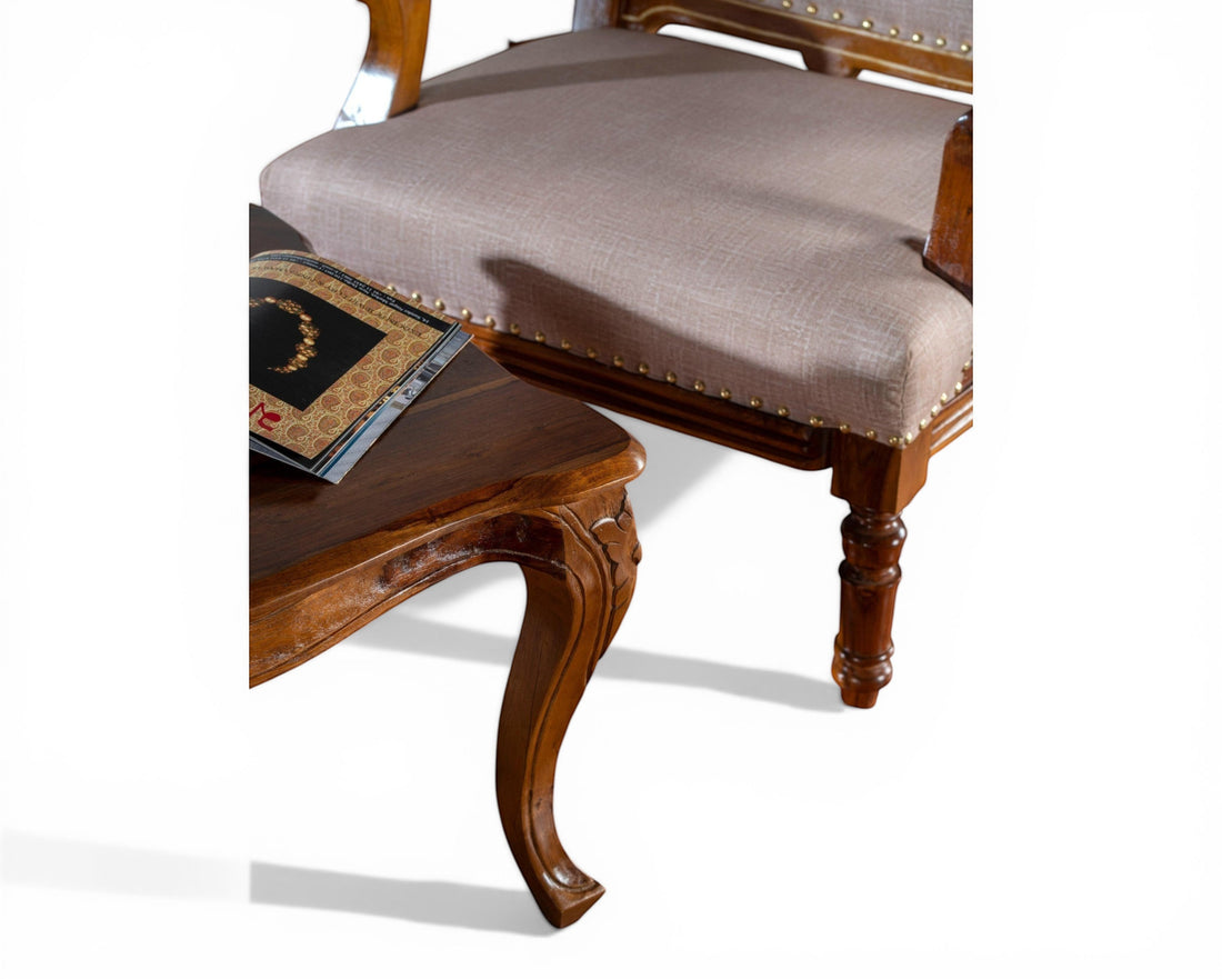 Nakoda Homes ornate carved wood armchair with neutral upholstered seat and nailhead trim, perfect for classic decor.