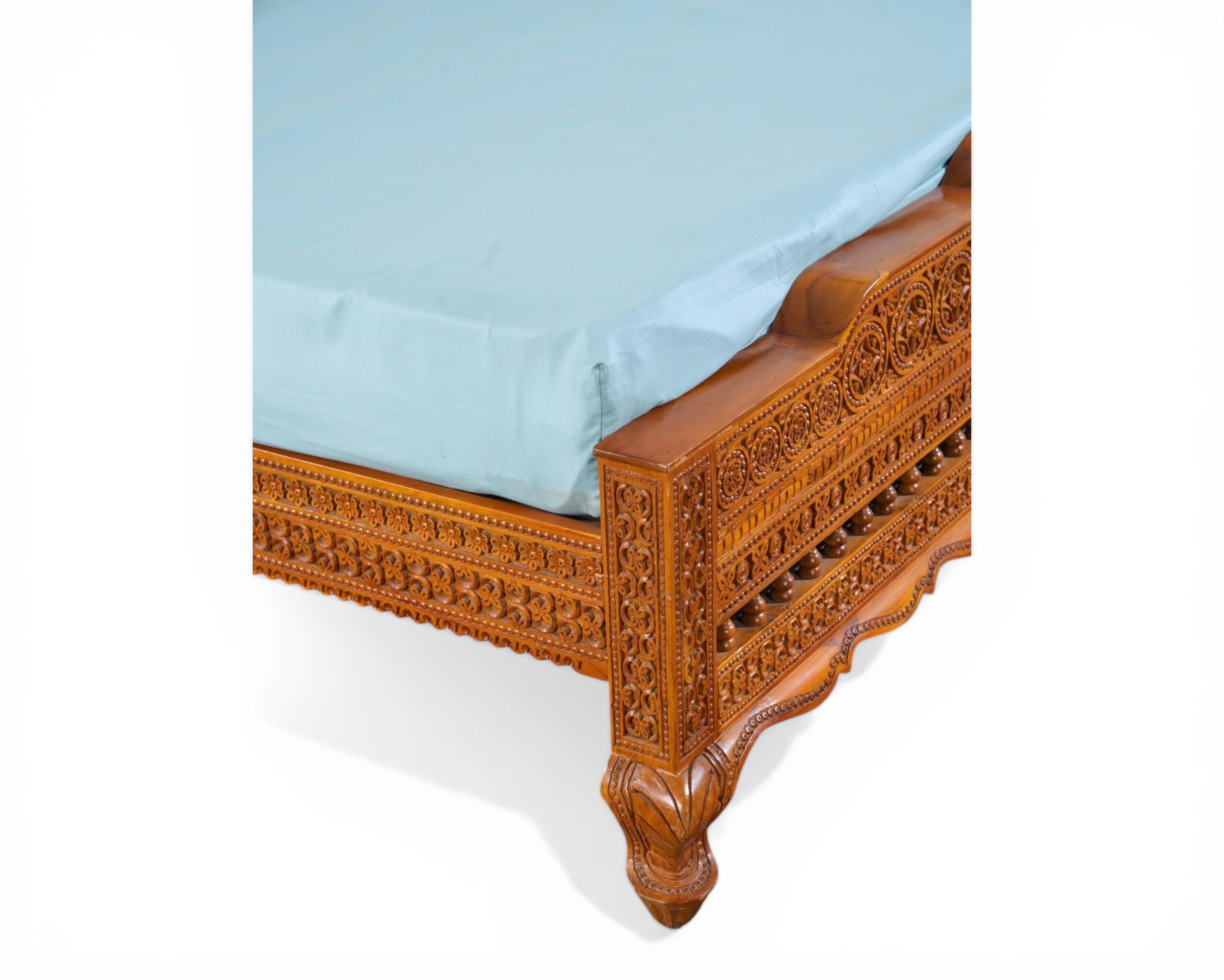 Nakoda Homes ornate carved wooden bed frame with intricate details and warm wood finish. Traditional craftsmanship.