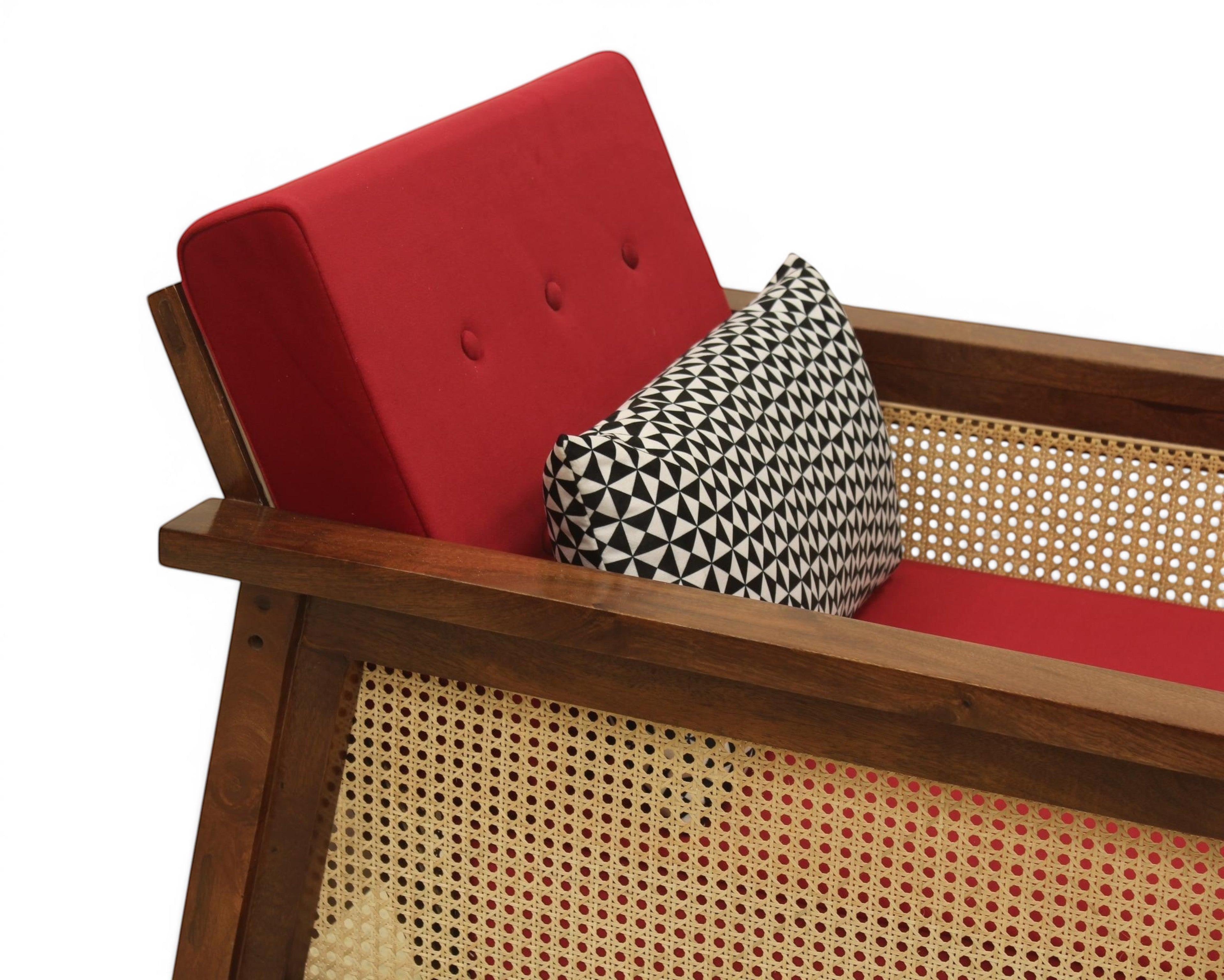 Nakoda Homes red upholstered armchair with wooden frame and cane detailing, includes patterned accent pillow.