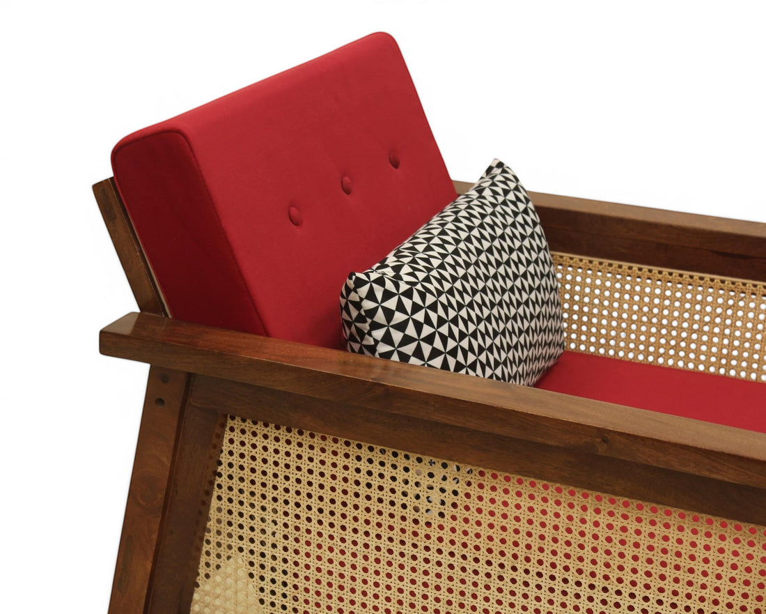Nakoda Homes red upholstered armchair with wooden frame and cane detailing, includes patterned accent pillow.