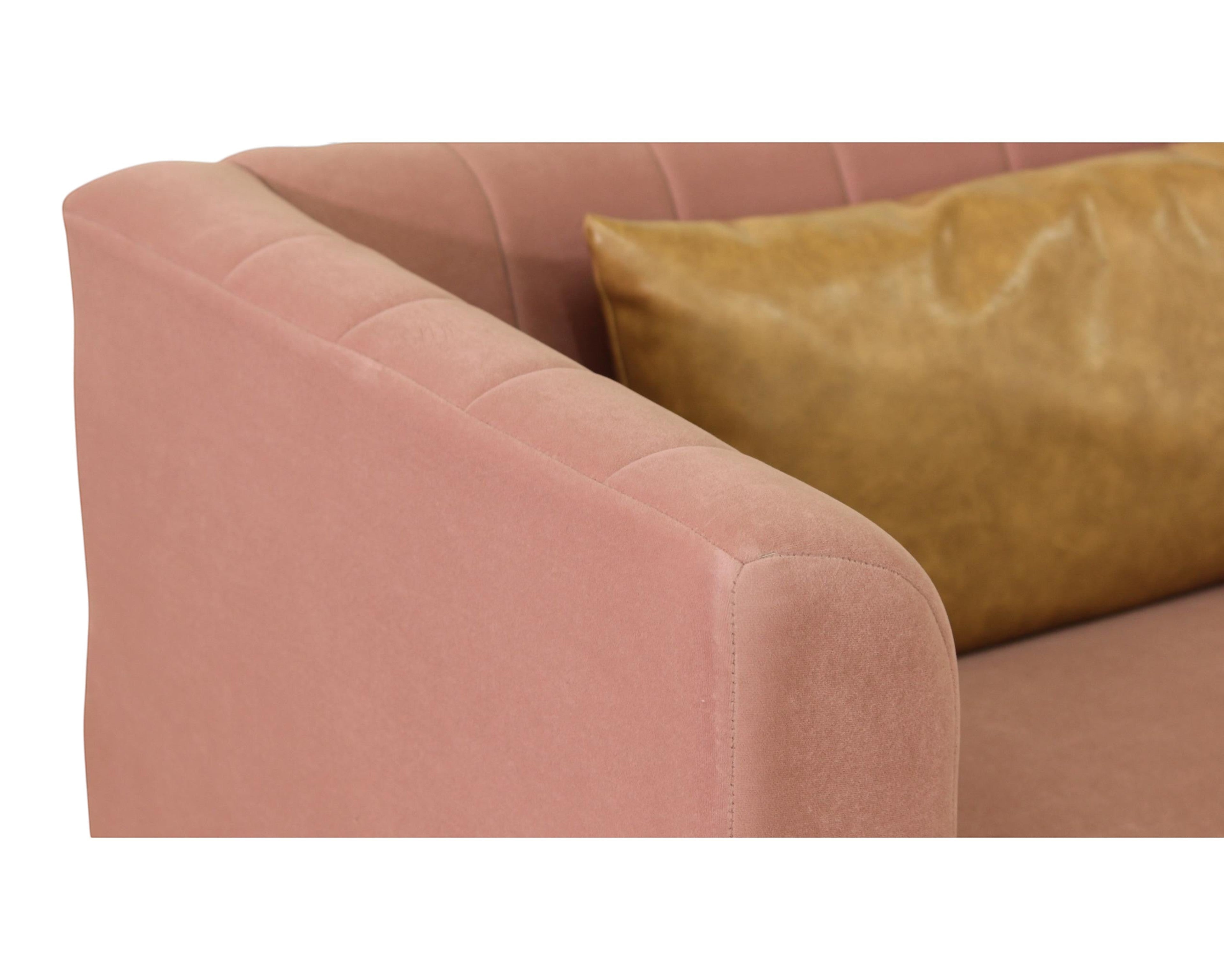 Nakoda Homes modern rose velvet sofa with channel tufting and faux leather accent pillow.