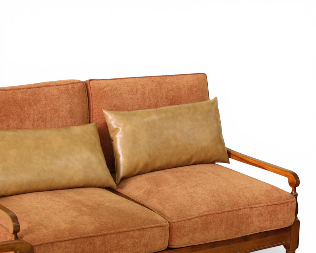 Nakoda Homes rust-colored upholstered sofa with tan faux-leather lumbar pillows and wooden armrests.