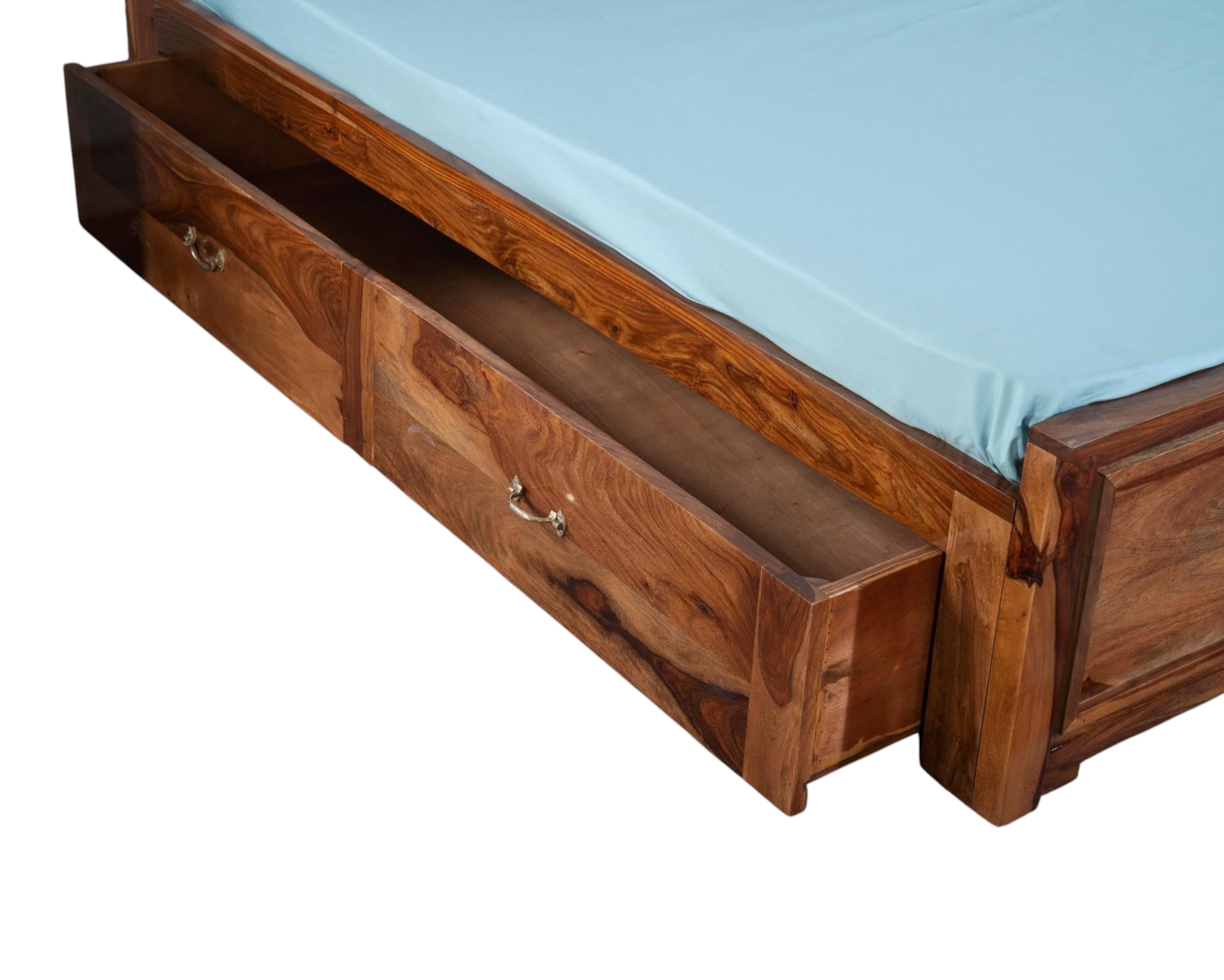 Nakoda Homes Sheesham wood bed frame with geometric carved headboard and storage drawers. Natural wood grain.