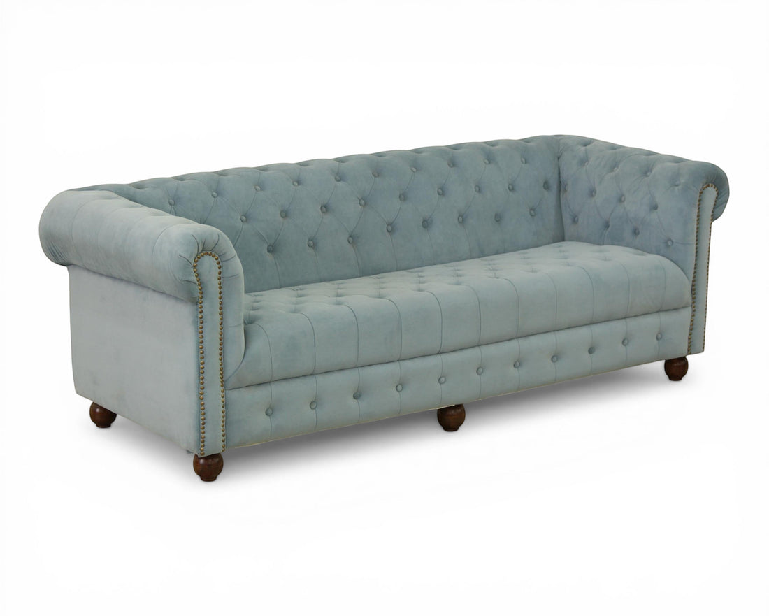 Nakoda Homes sky-blue velvet Chesterfield sofa with deep button-tufting, rolled arms, and nailhead trim.