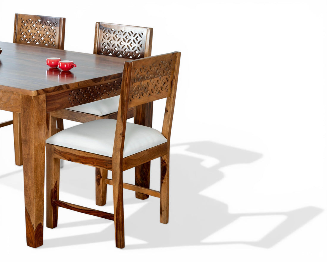 Nakoda Homes solid wood dining set with intricately carved chair backs and white cushioned seats.
