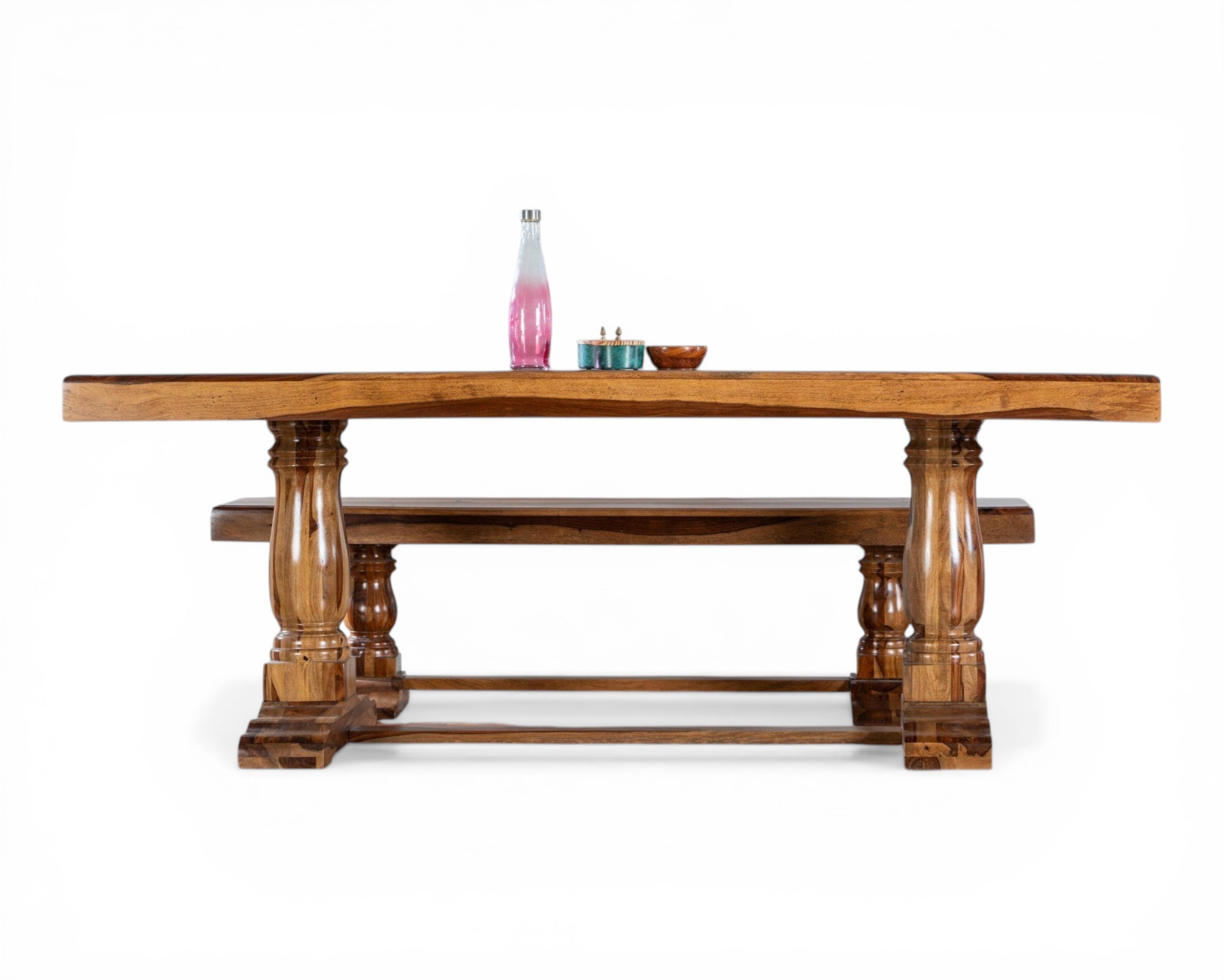 Nakoda Homes solid wood dining table with matching benches, featuring a warm-toned finish and carved pedestal legs.