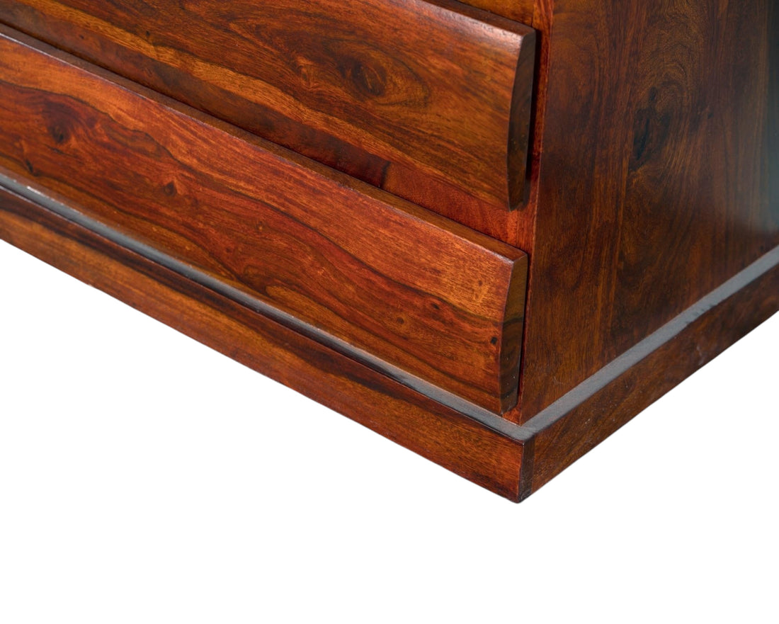 Nakoda Homes solid wood dresser in warm brown with five drawers featuring subtly curved fronts and natural wood grain.