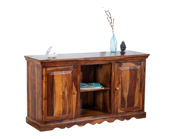 Nakoda Homes solid Sheesham wood media console with two cabinets and open shelf, featuring natural grain patterns and scalloped base.