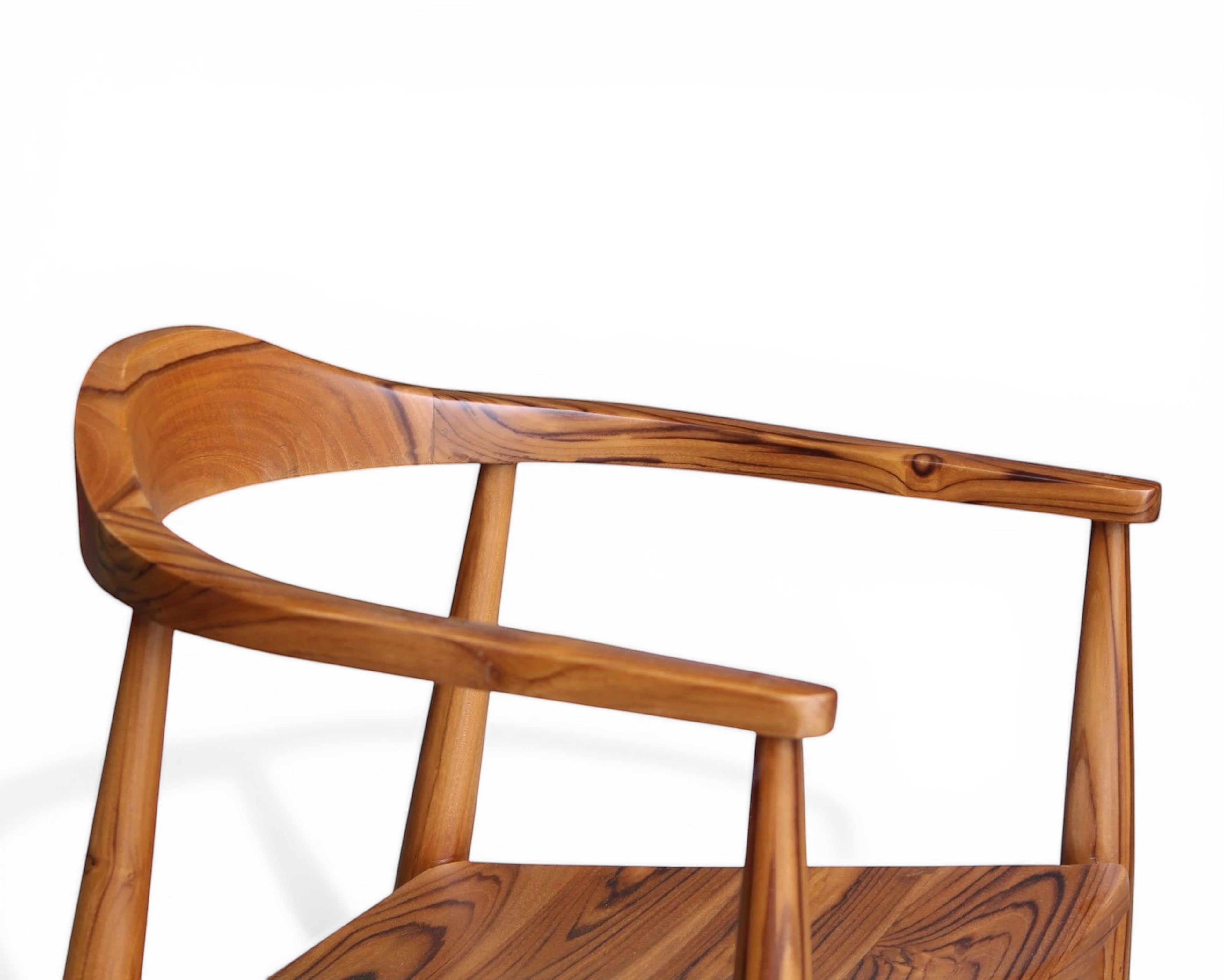Nakoda Homes solid wood dining chair with curved back and natural grain finish.