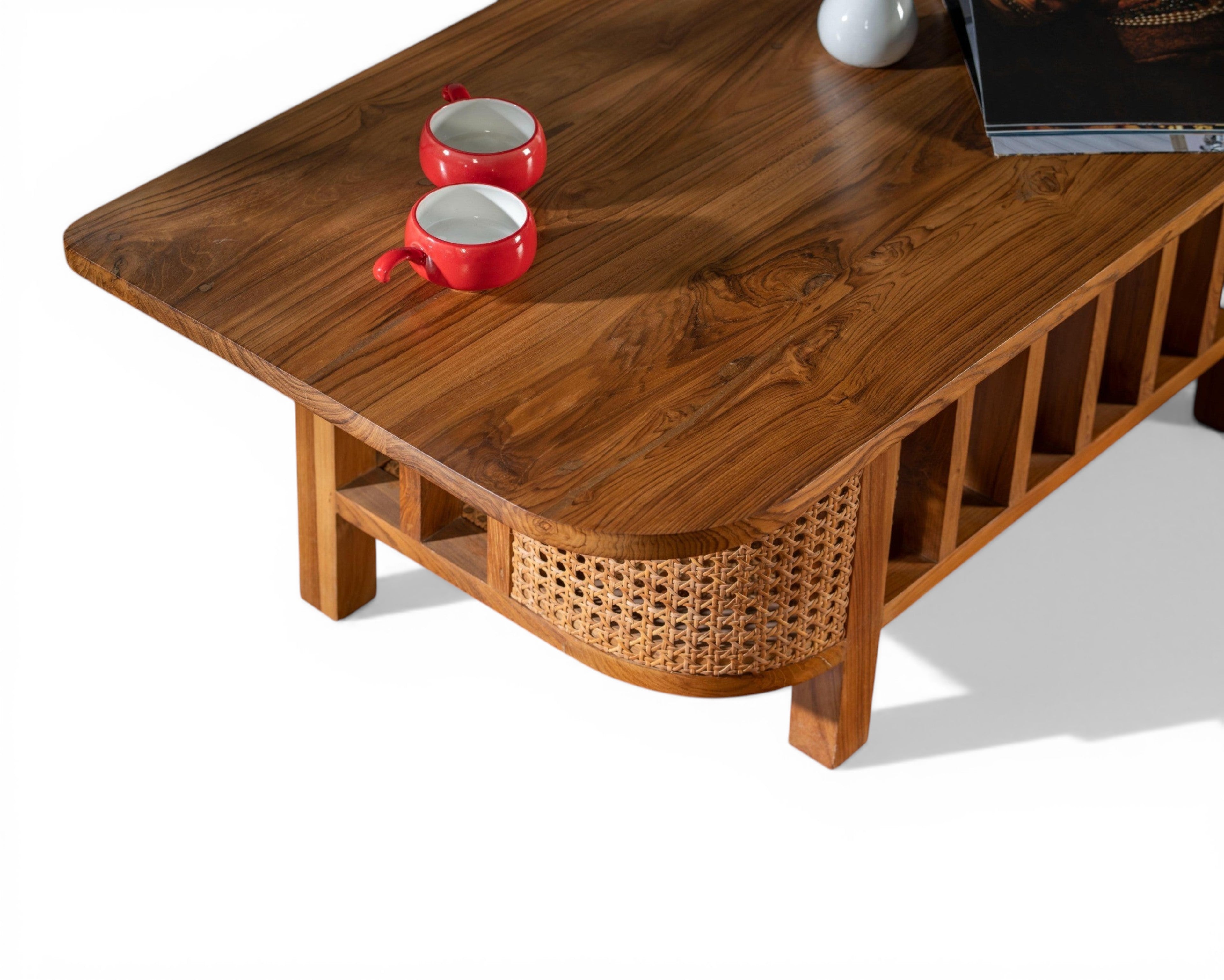 Nakoda Homes natural wood coffee table with cane detailing and slatted sides. Features a curved front with woven cane.