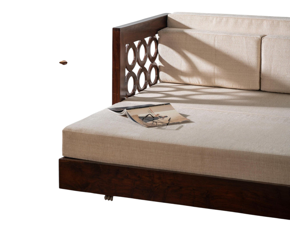 Nakoda Homes dark wood daybed with neutral upholstered seat and circular cut-out armrests.