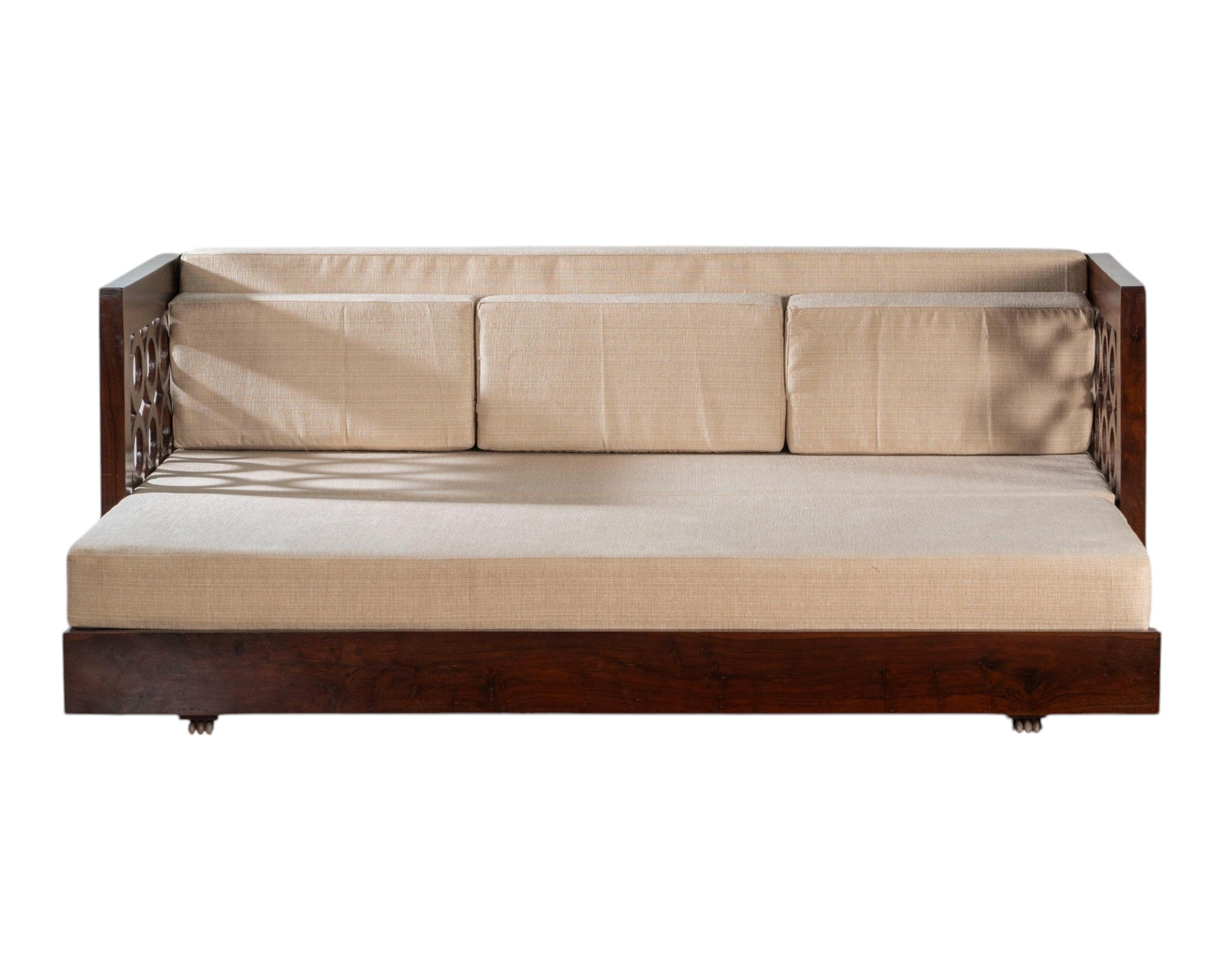 Nakoda Homes dark wood daybed with neutral upholstered seat and intricate circular armrest detailing.