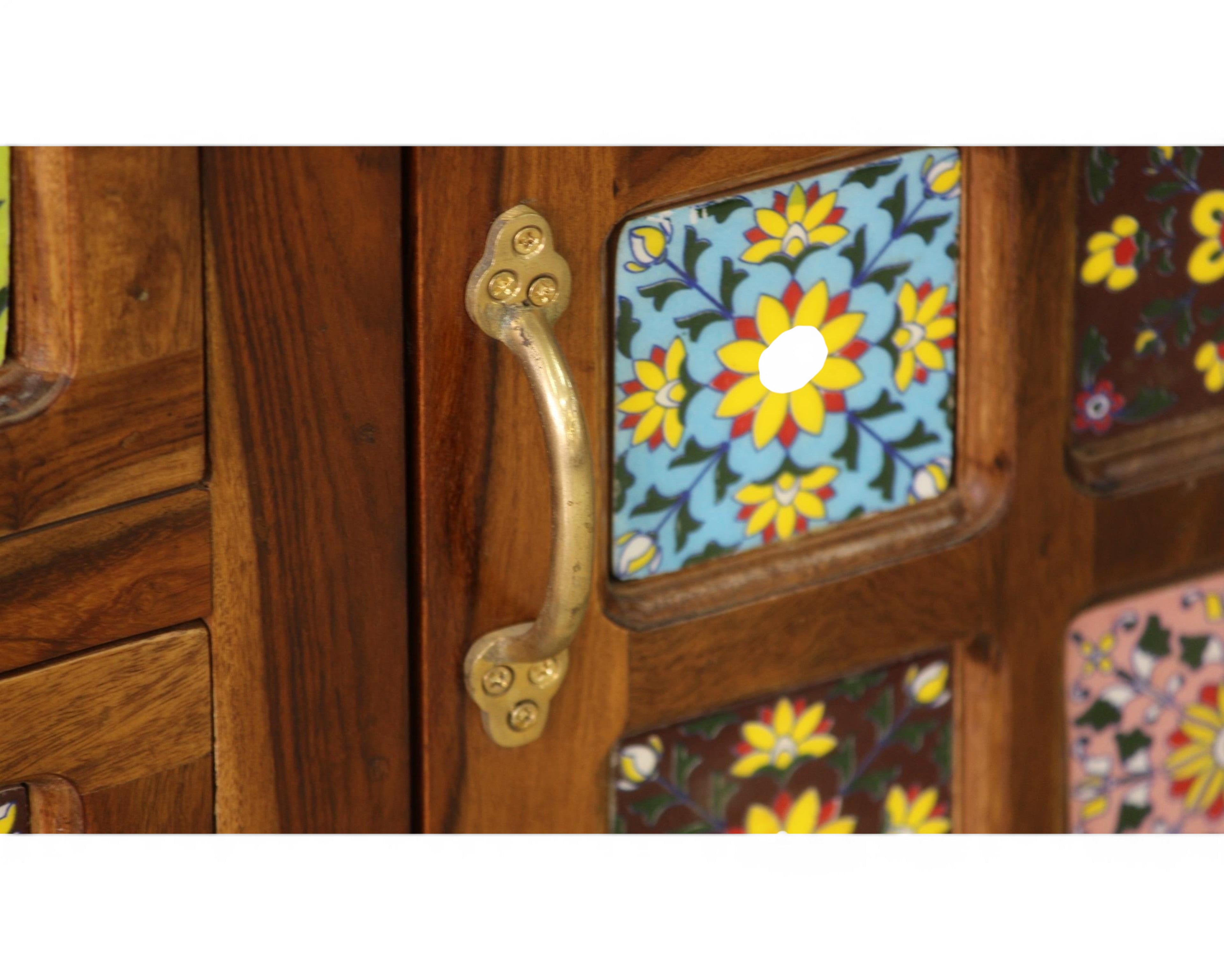 Nakoda Homes wooden cabinet with hand-painted floral tiles in blue, yellow, and brown, featuring brass hardware.