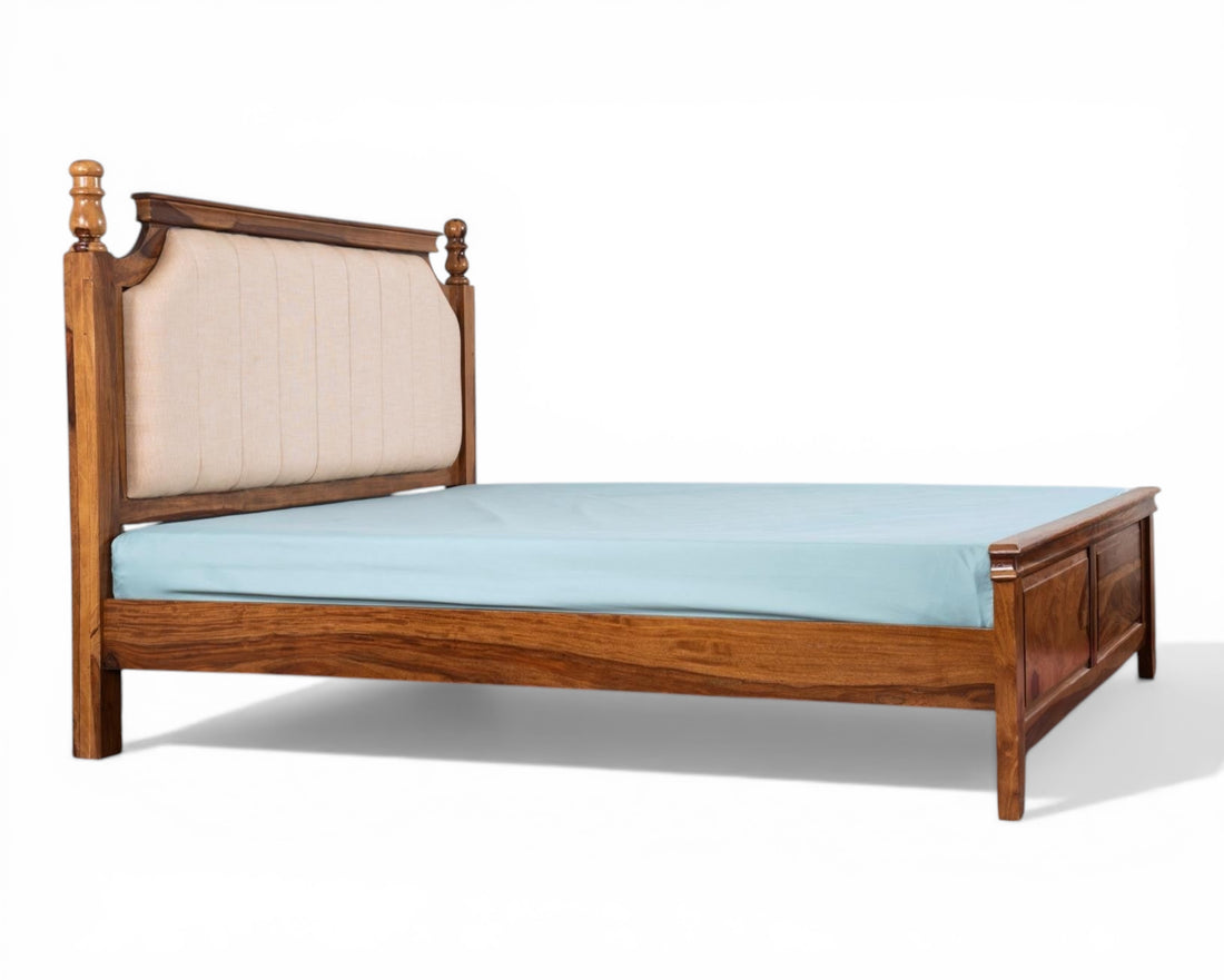 Nakoda Homes classic wooden bed frame with upholstered beige headboard and decorative accents.