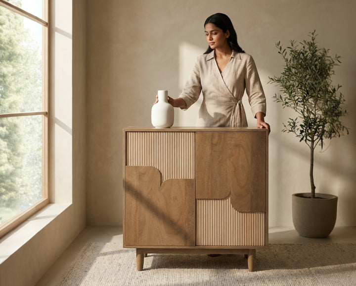 Nakoda Homes Art Deco Ridge Cabinet in wood with fluted paneling and asymmetric doors on tapered legs.