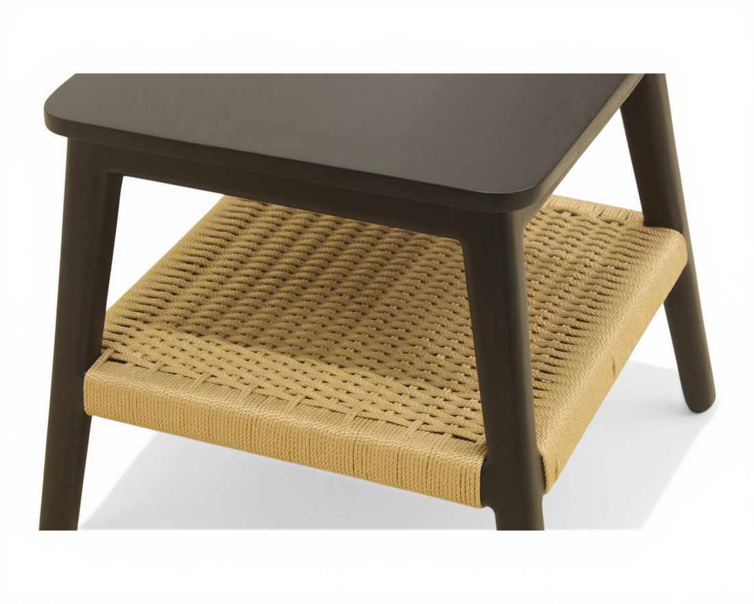 Nakoda Homes modern side table with black wooden frame and natural woven rattan shelf. Ideal accent piece.