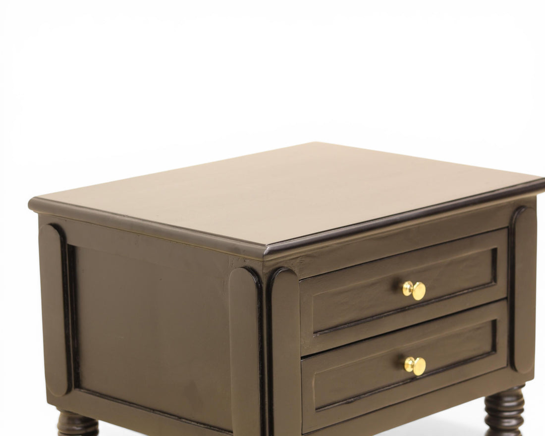 Nakoda Homes black wooden nightstand with two drawers, gold hardware, and decorative legs. Offers classic bedroom storage.