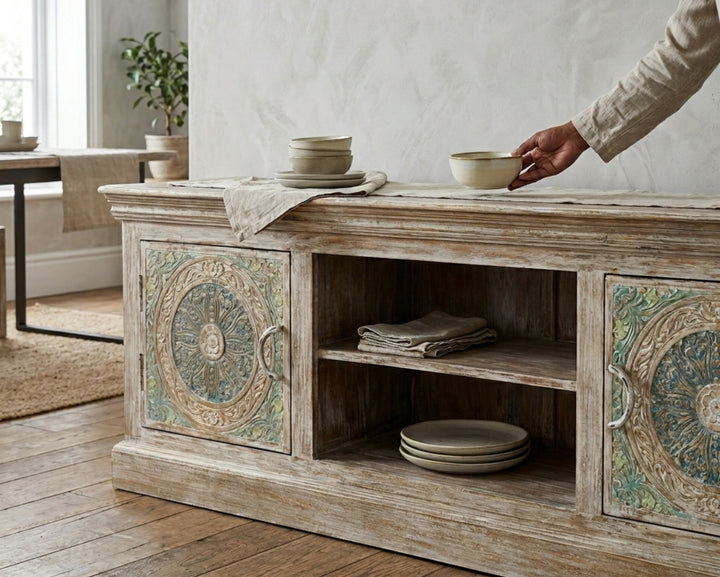 Nakoda Homes Calista TV unit in distressed wood with hand-carved floral and geometric patterns on doors.