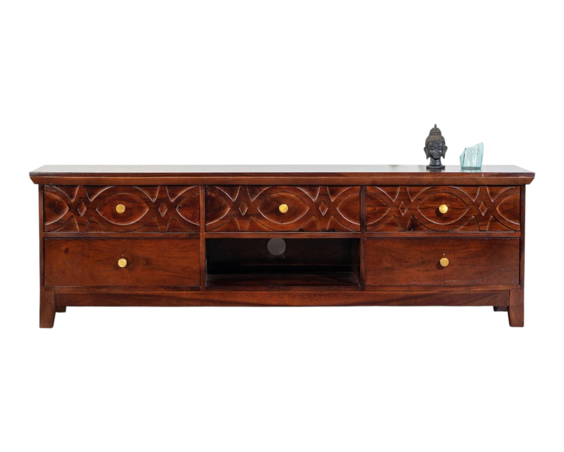 Nakoda Homes dark wood media console with carved geometric drawer fronts and brass hardware.